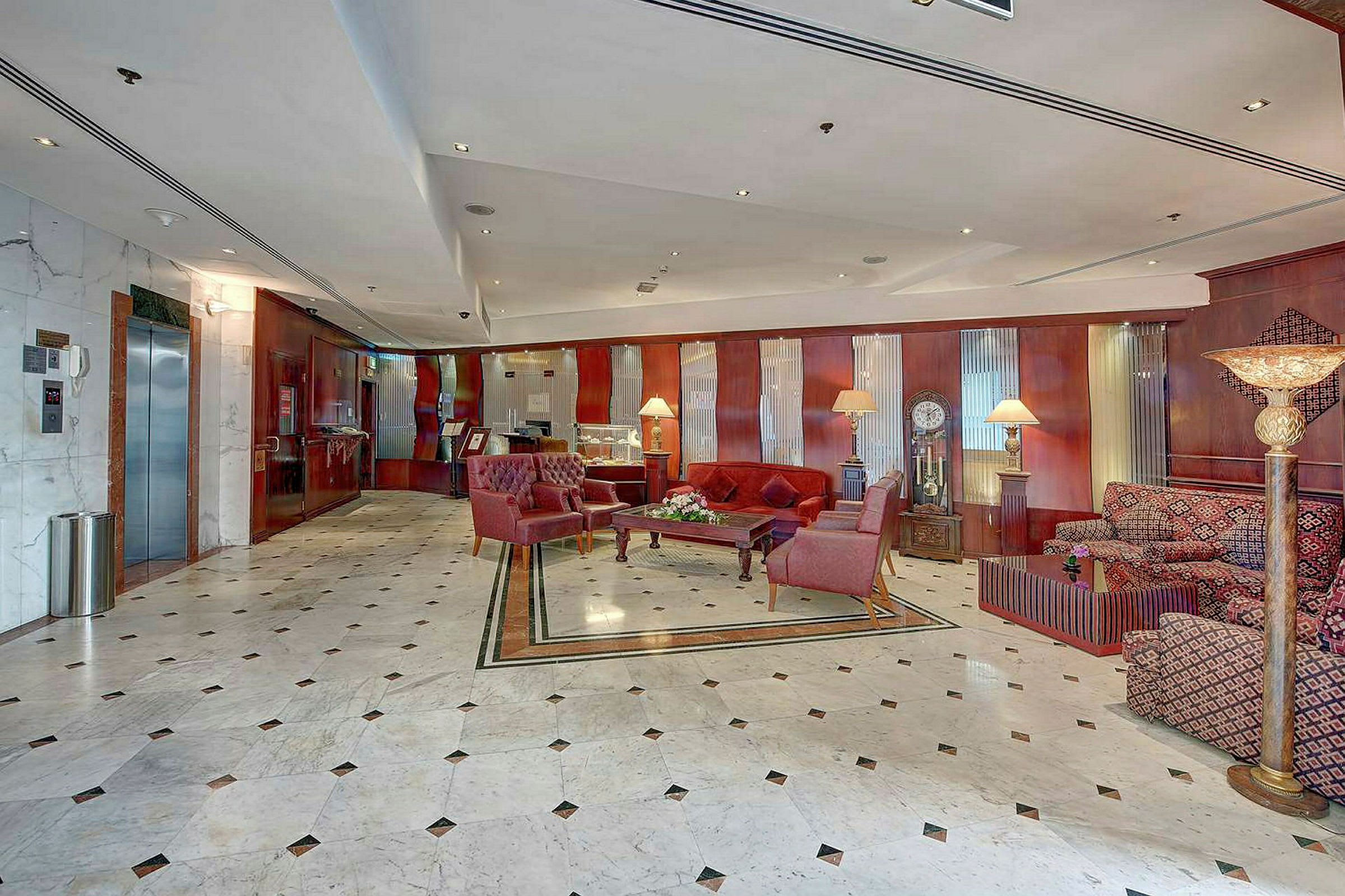 Ett rymligt hotellobby med marmorgolv och inredning med bekväma fåtöljer och soffor. (AI-genererad text)