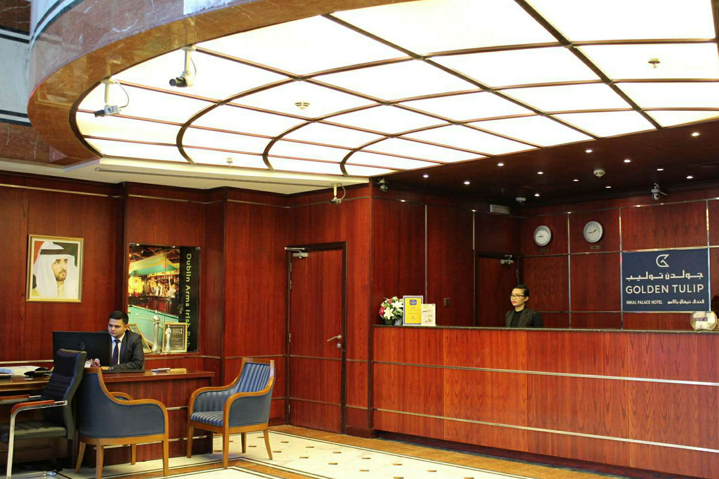 Hotellets receptionsområde med en träinredd disk och sittplatser. (AI-genererad text)