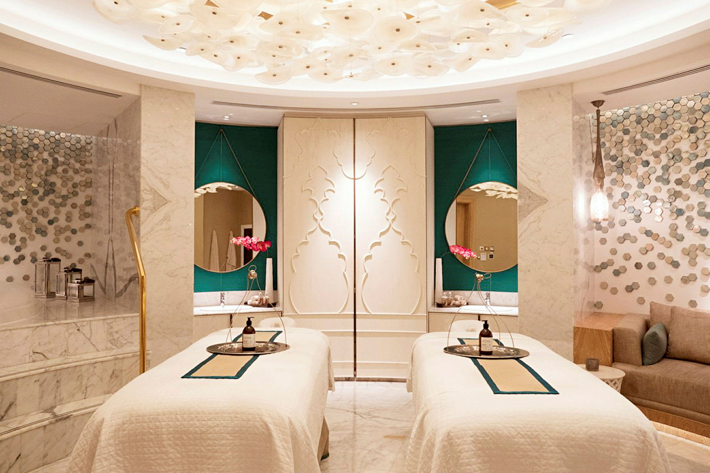 Ett elegant spa-rum med två behandlingsbäddar, dekorativa speglar och stiliga detaljer. (AI-genererad text)