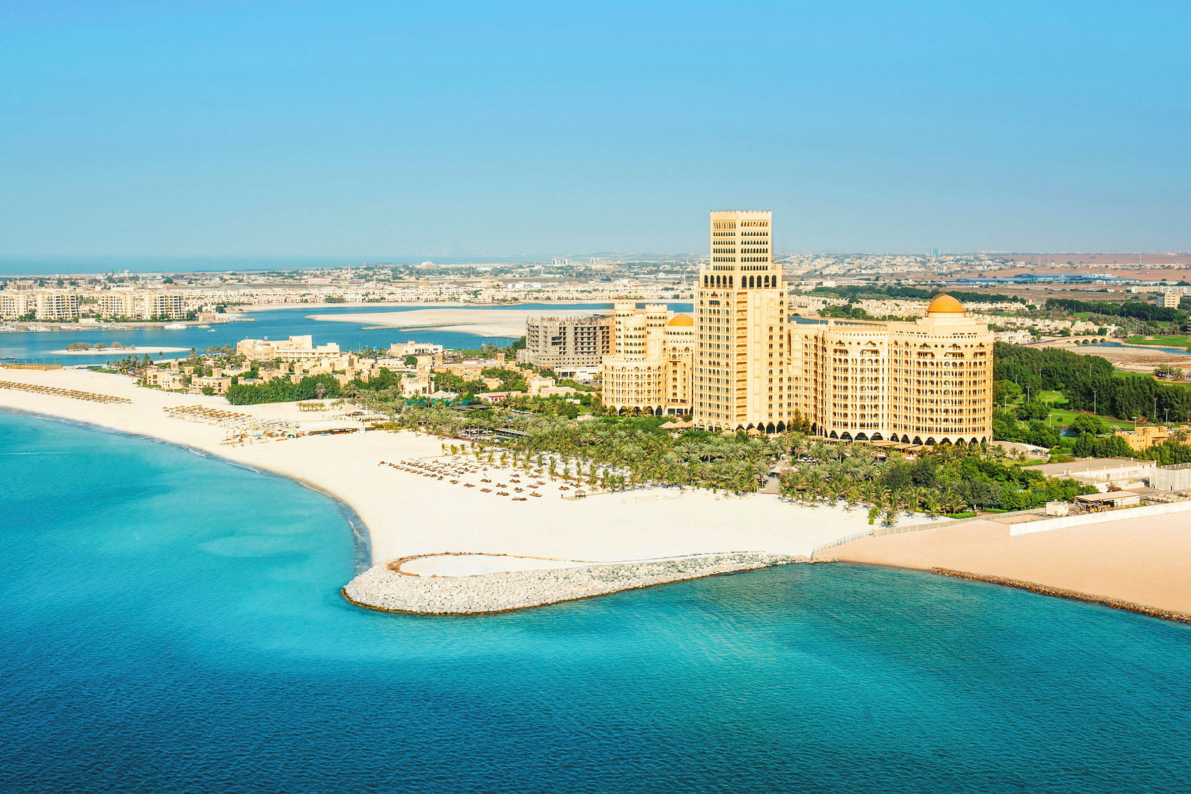 Strand med hotellbyggnad i bakgrunden. (AI-genererad text)