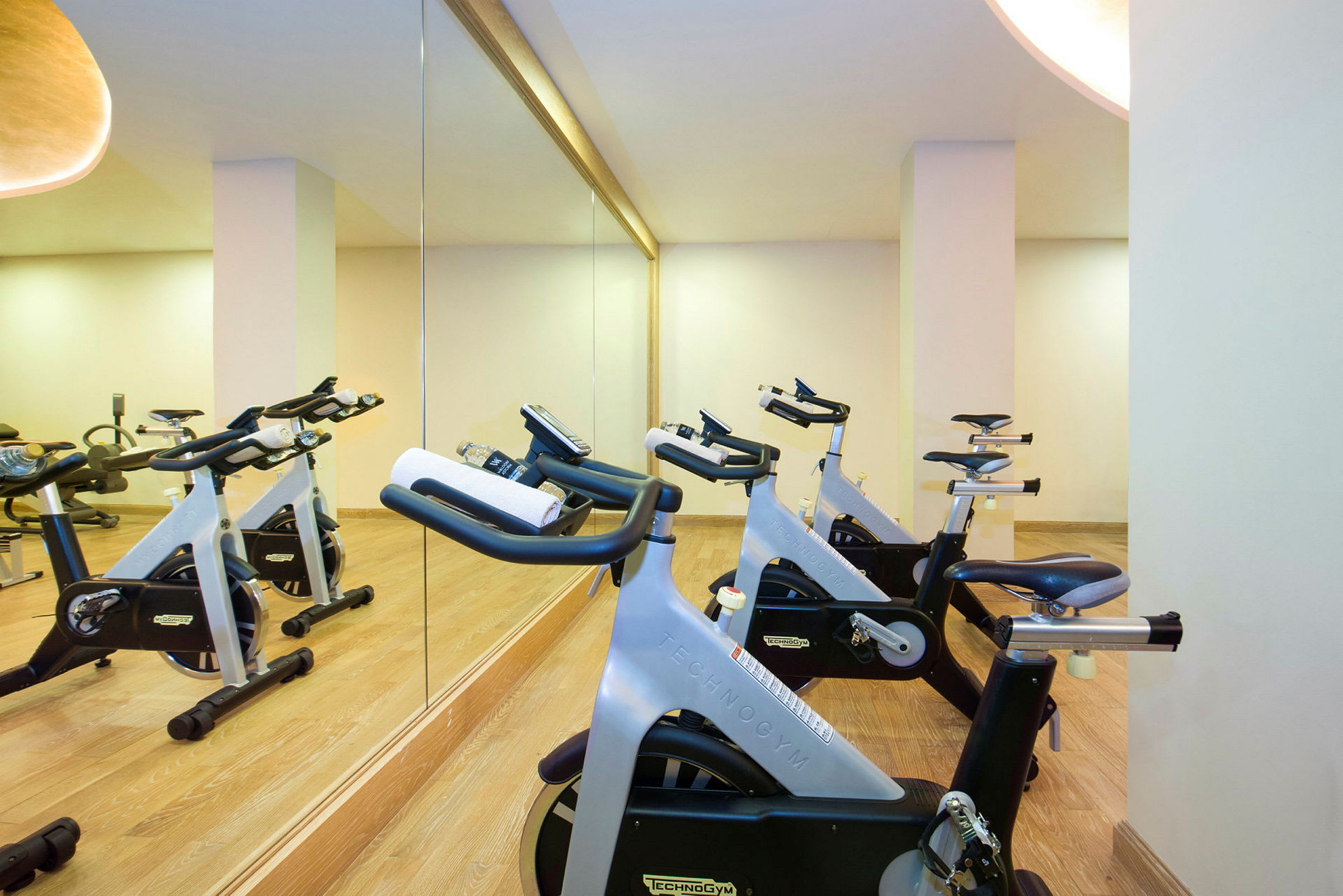 Bild av träningscyklar i ett gym med spegelvägg. (AI-genererad text)