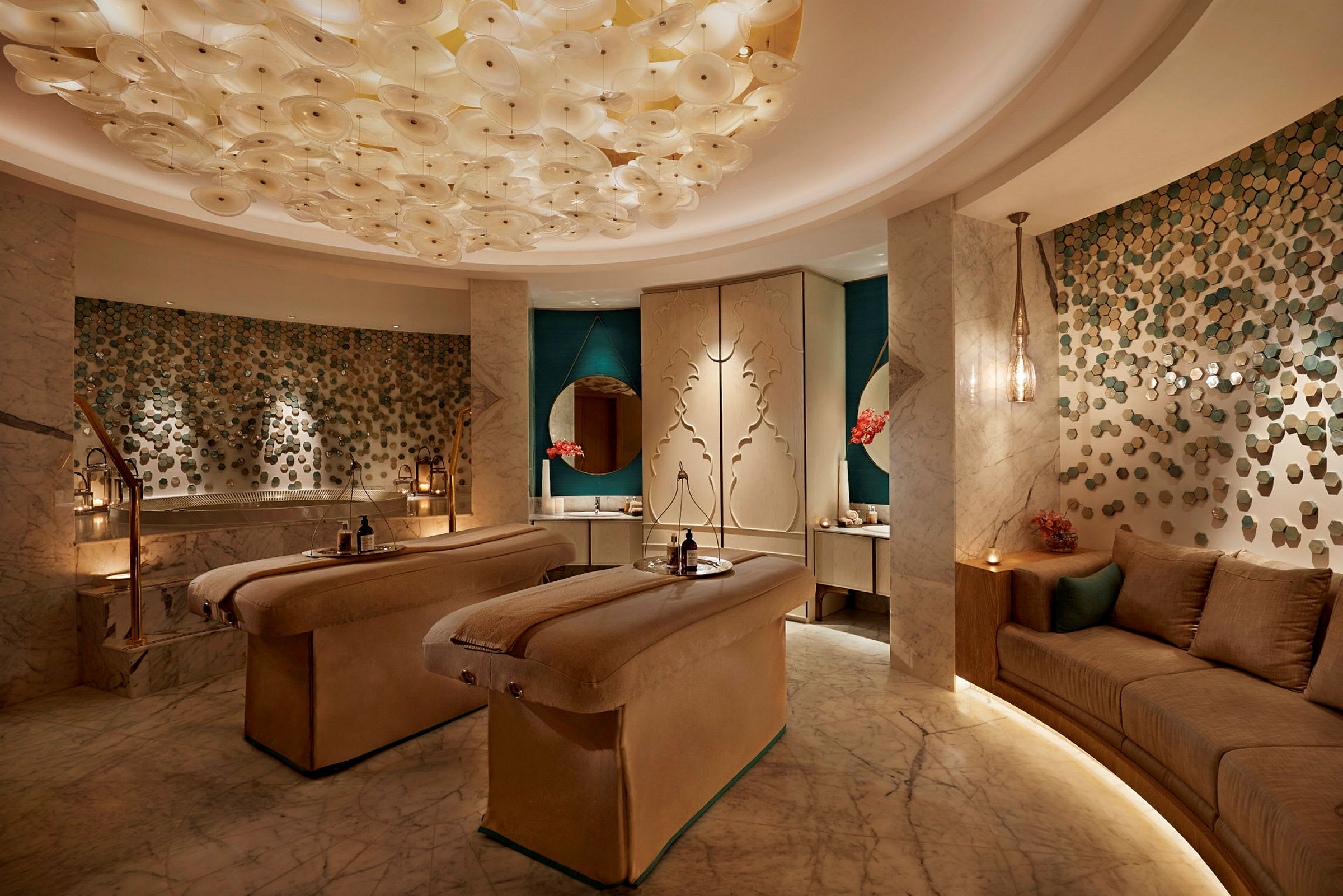 Spa-interiör med två massagebänkar, dekorativ belysning och sittområde. (AI-genererad text)