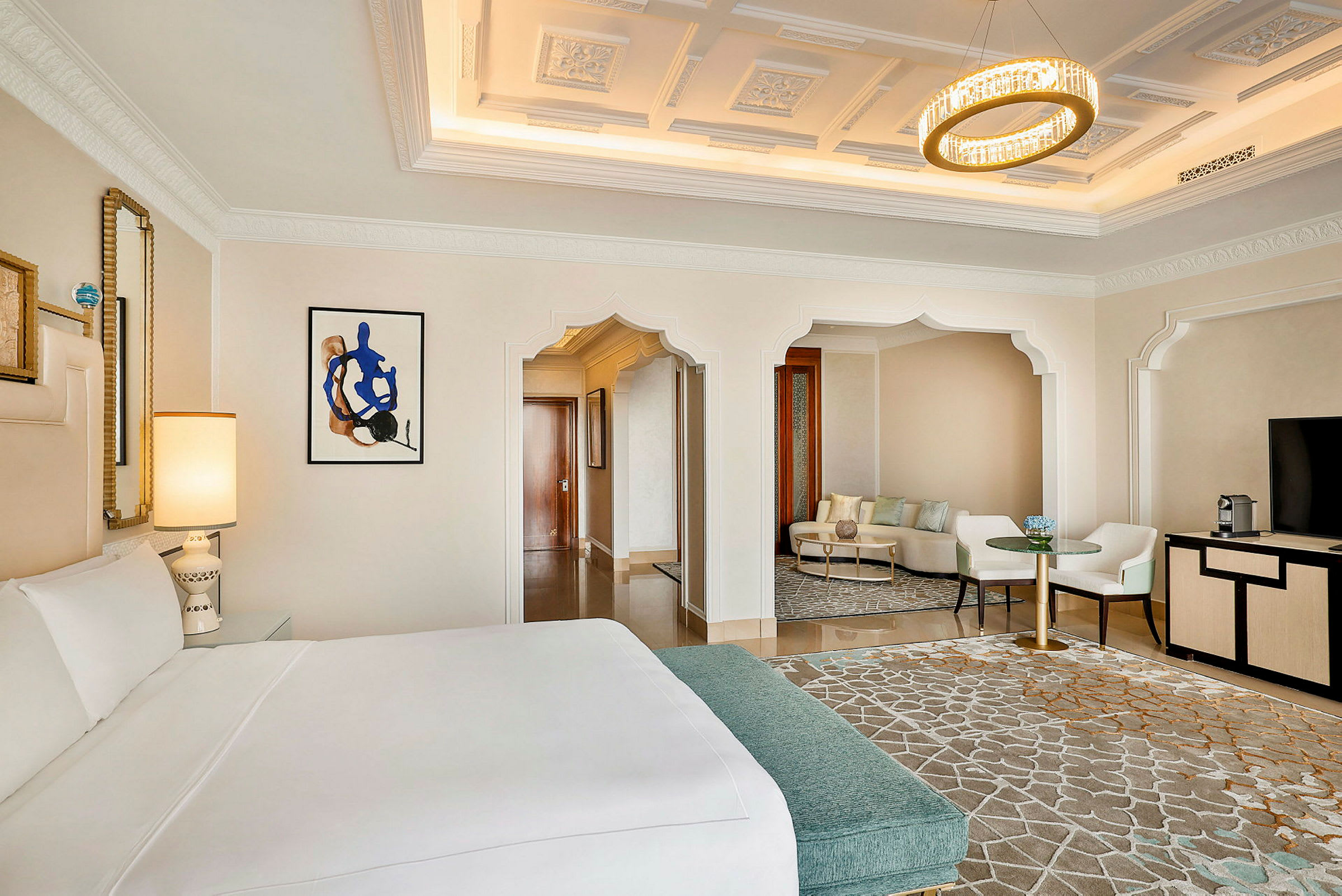 Elegant hotellrum med stor säng, sittgrupp och stilfull belysning. (AI-genererad text)