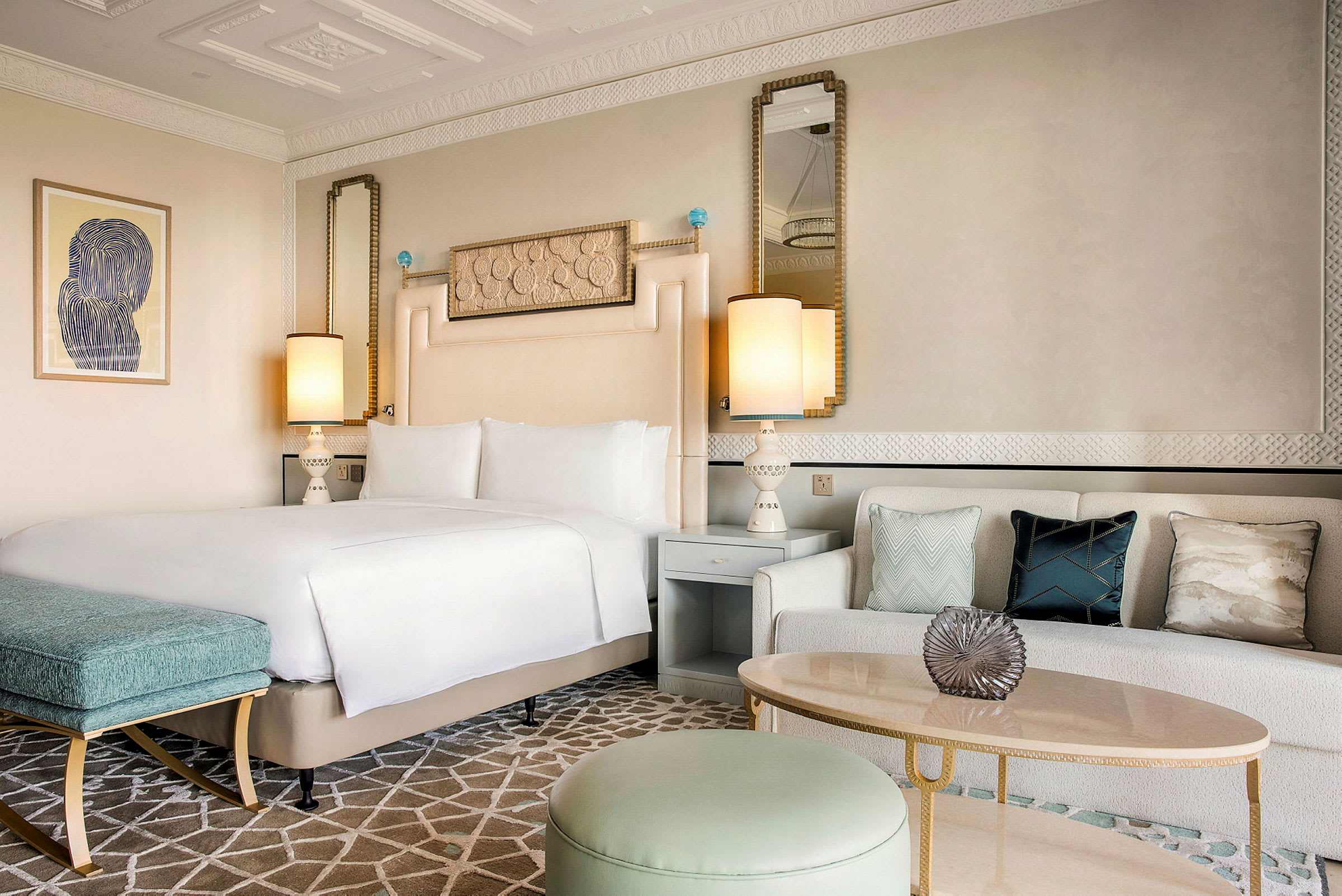 Ett elegant hotellrum med en dubbelsäng, en soffa med prydnadskuddar och ett stilfullt bord. (AI-genererad text)