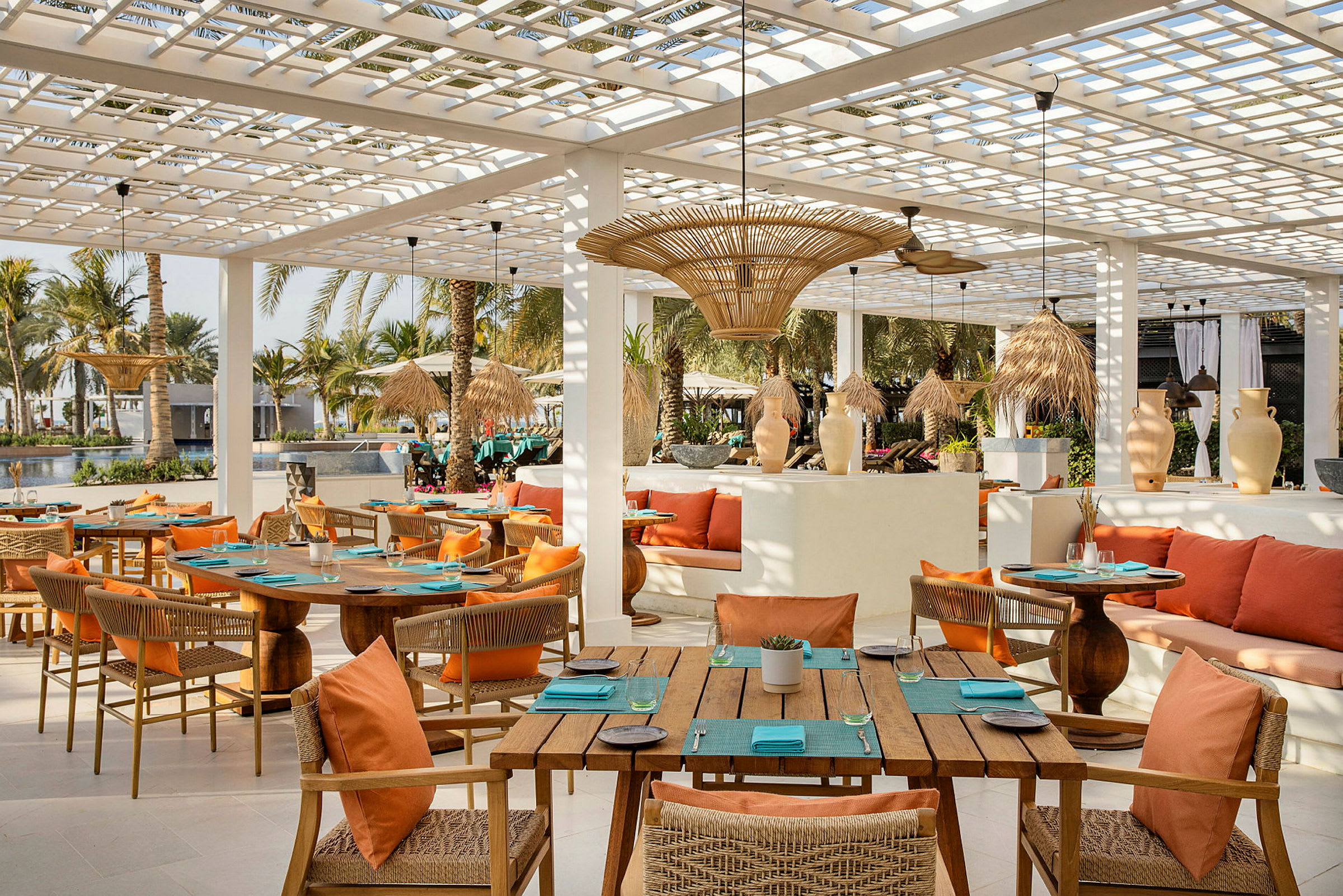 Restaurang med trämöbler och orange kuddar på terrass. (AI-genererad text)