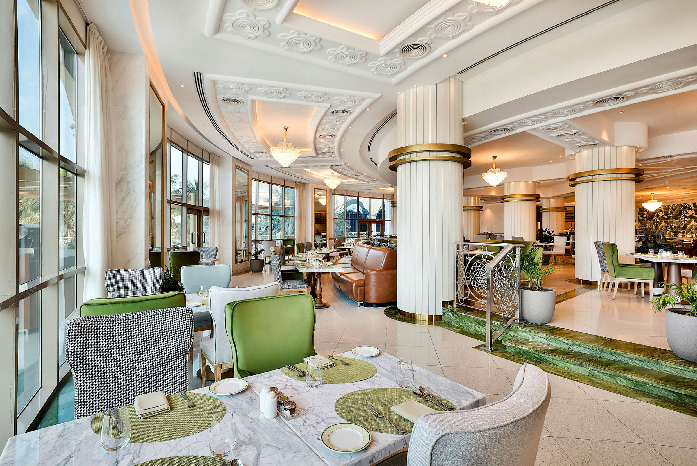 Interiör av en modern restaurang med eleganta möbler och stora fönster. (AI-genererad text)