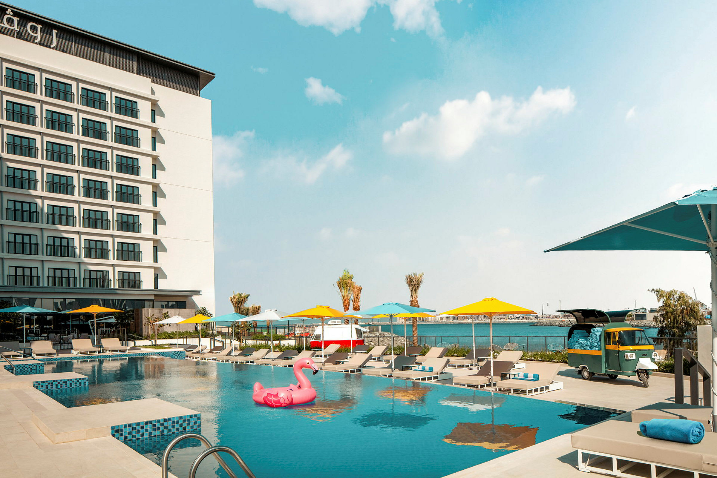 Hotellfasad med utomhuspool och solstolar. (AI-genererad text)