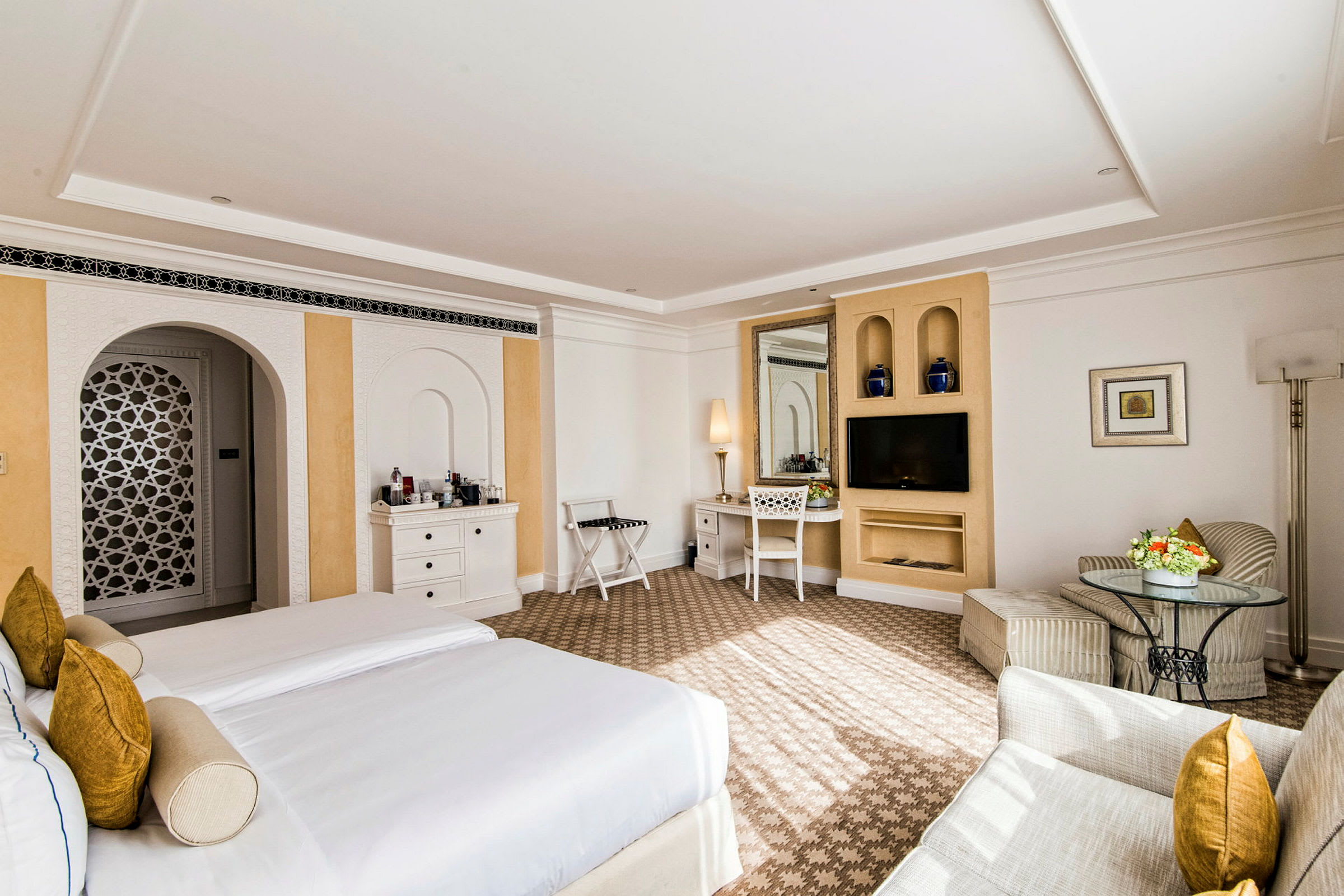 Ett hotellrum med två enkelsängar, sittgrupp och skrivbord. (AI-genererad text)