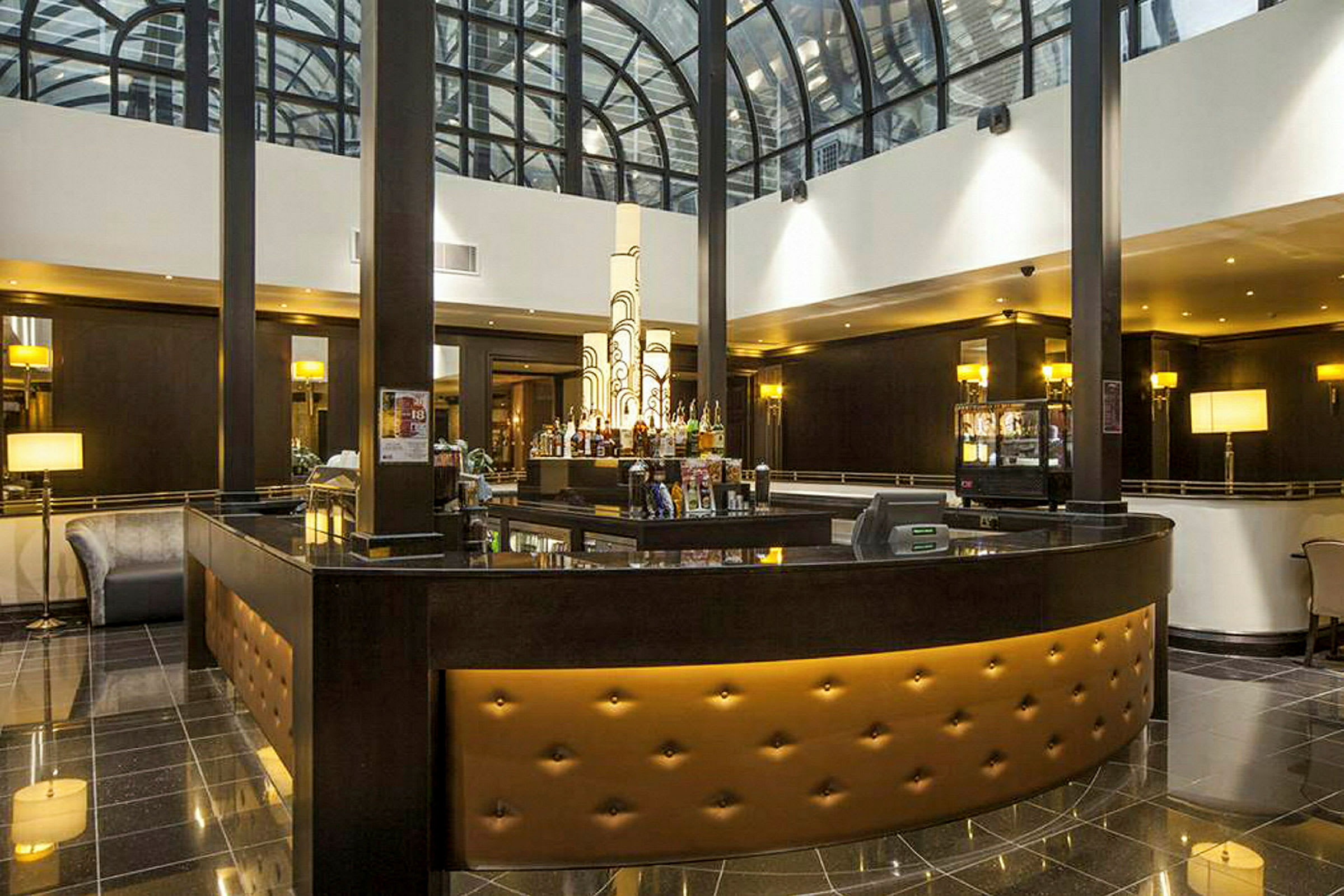 Hotellbar med elegant inredning och takfönster. (AI-genererad text)