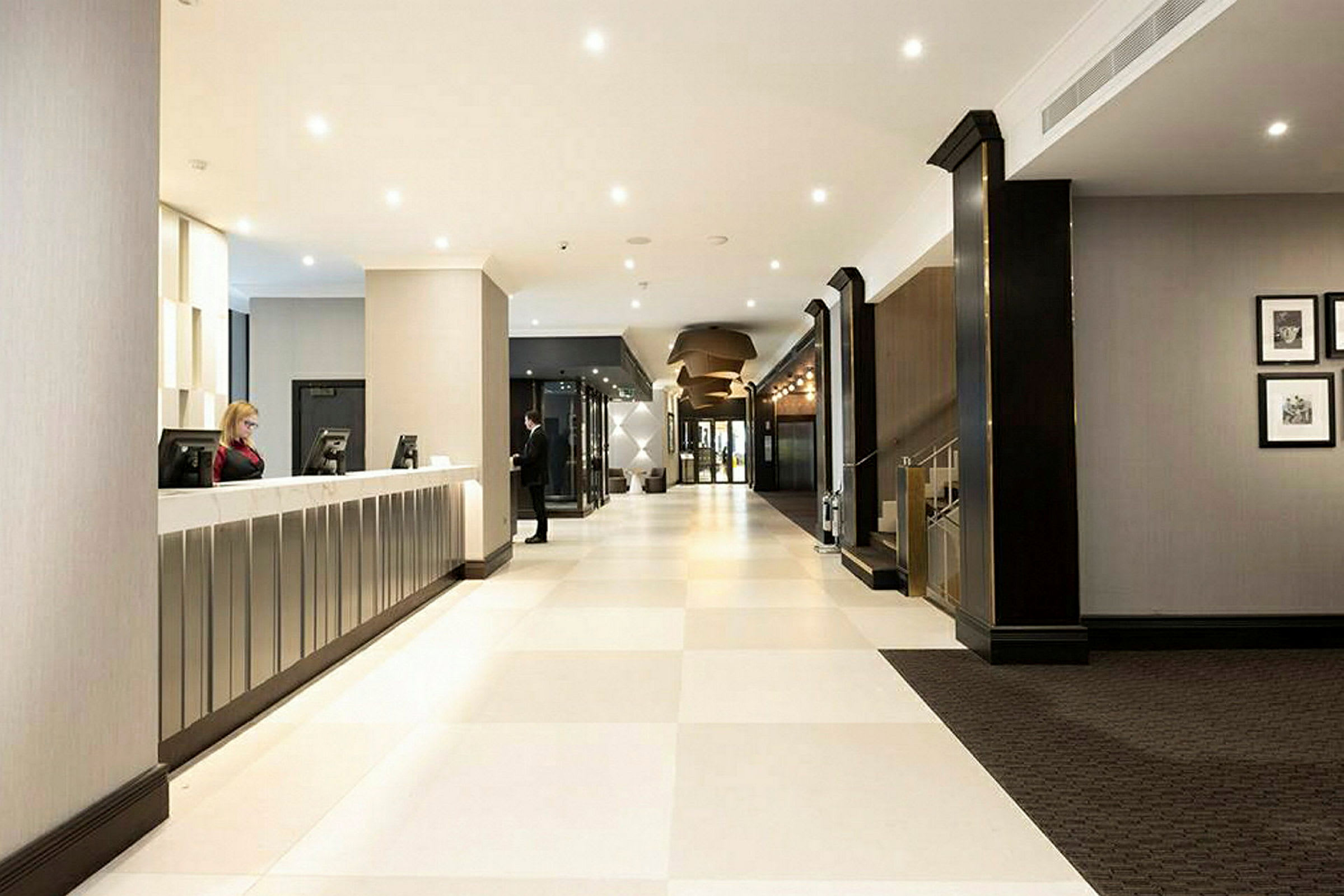 Hotellobby med receptionsdisk och ljusa golv. (AI-genererad text)