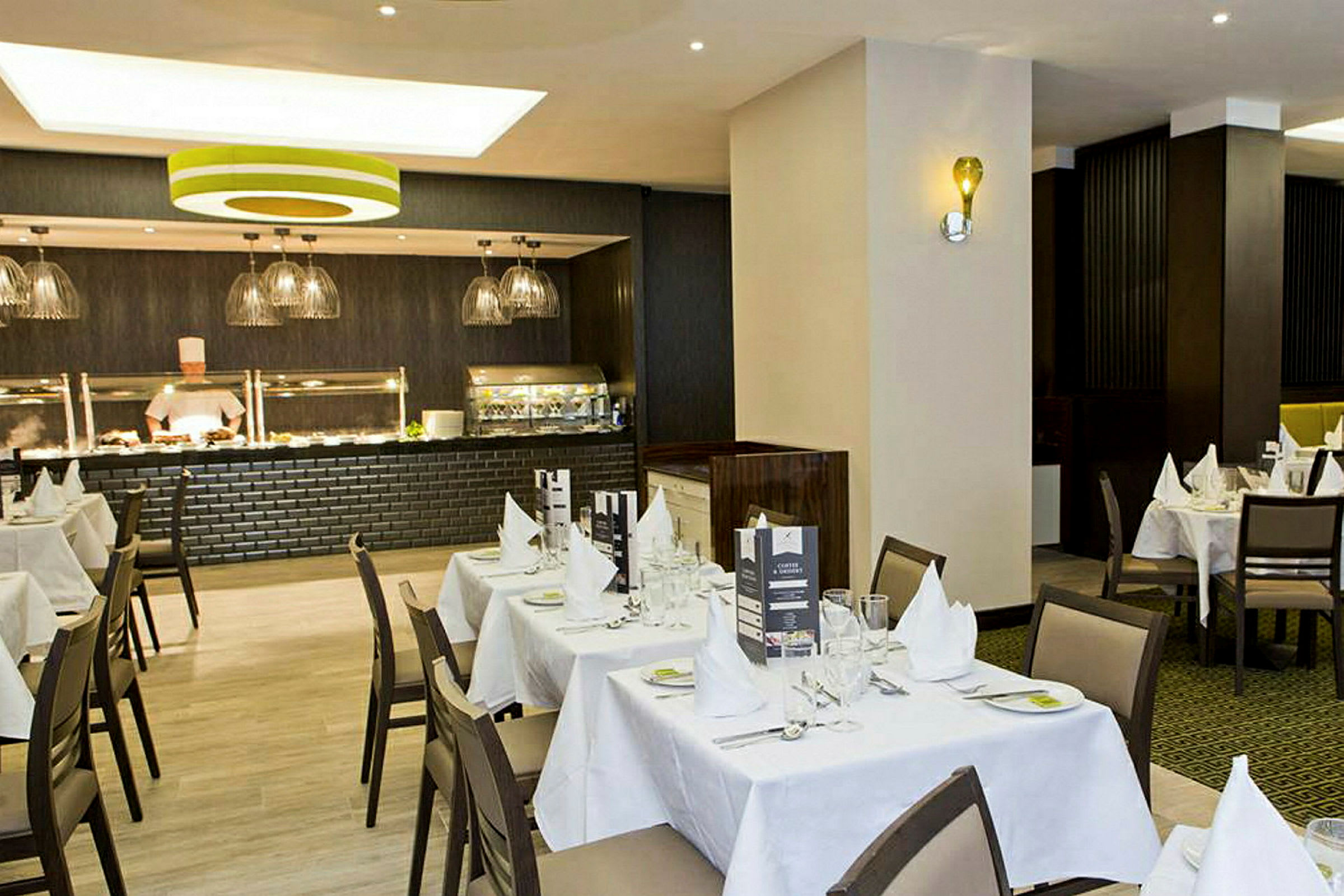 Restaurang med dukade bord och en buffetdisk. (AI-genererad text)