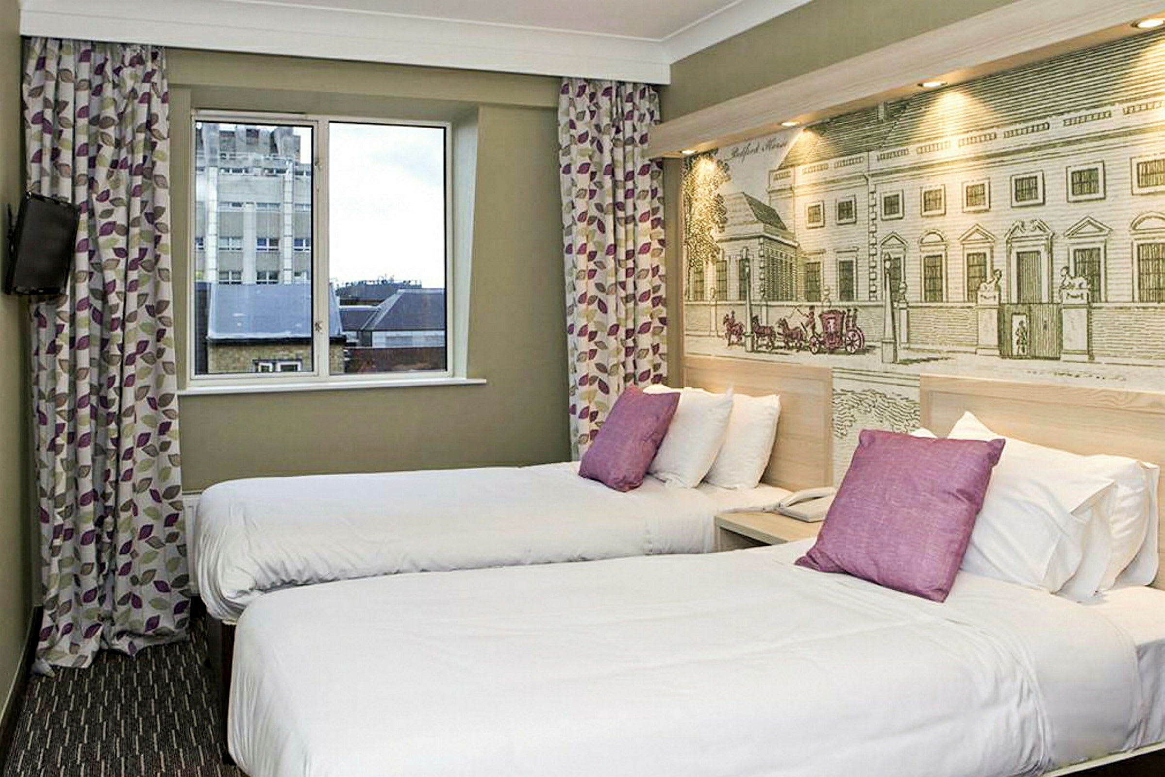 Ett hotellrum med två enkelsängar och dekorativ vägg bakom sängarna. (AI-genererad text)
