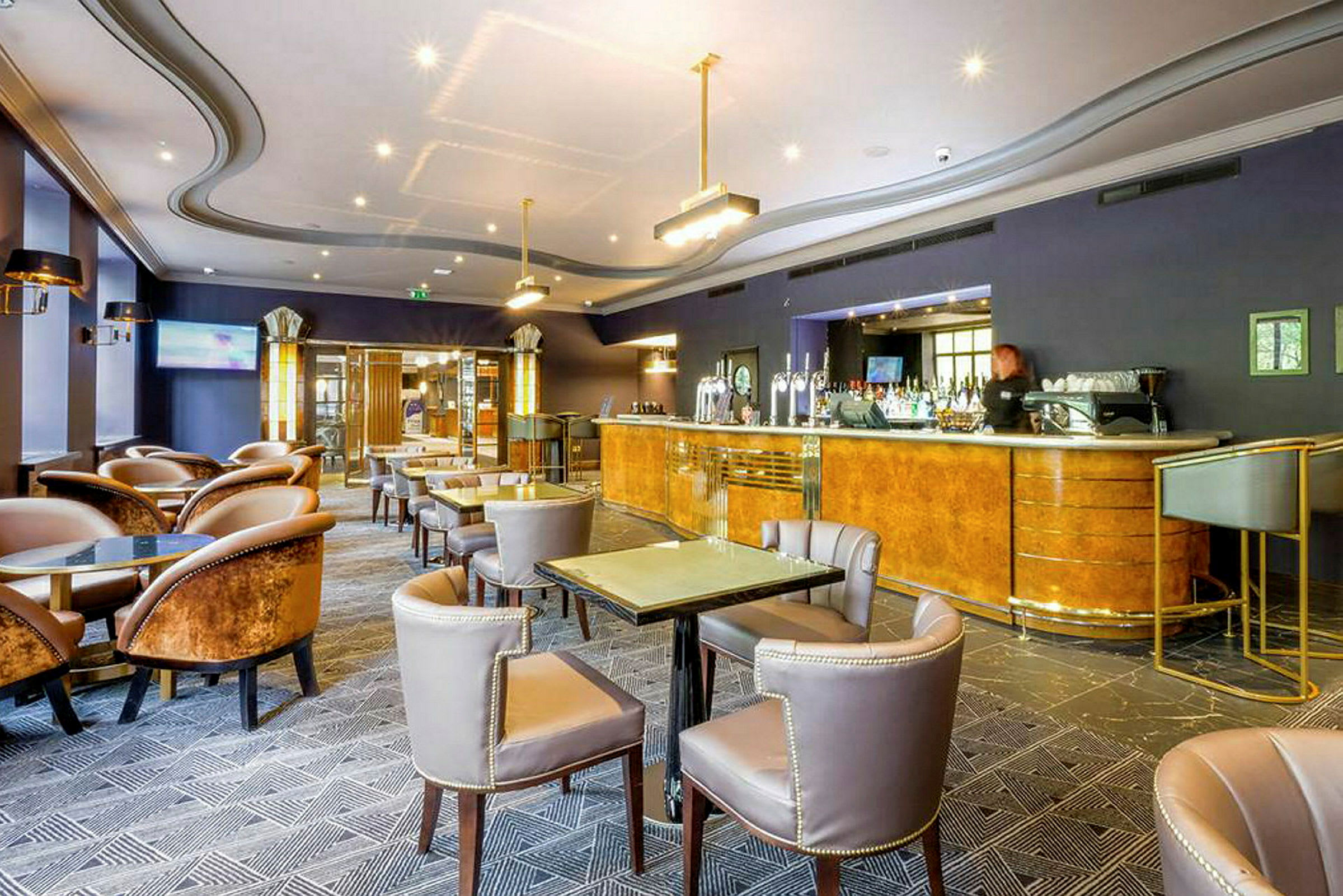 En hotellbar med bord och stolar samt en bardisk. (AI-genererad text)