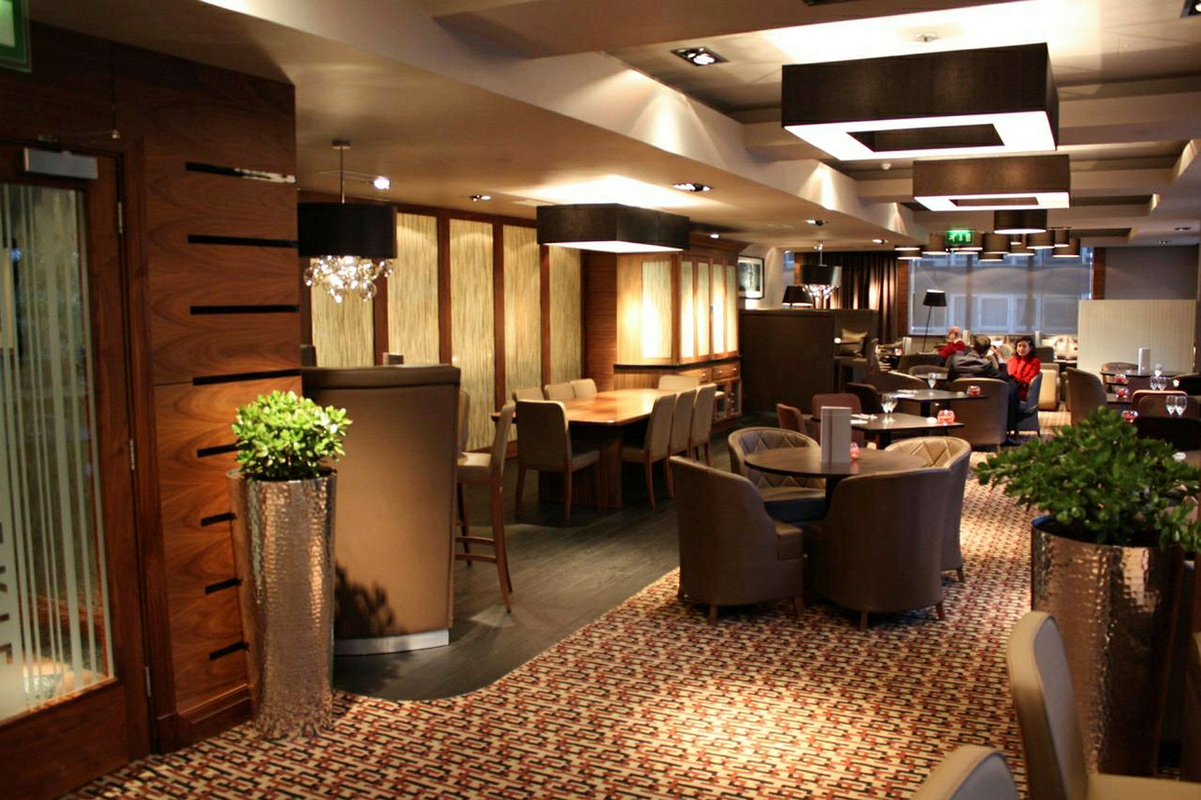 Interiör av en restaurang eller lounge med bord, stolar och elegant dekoration. (AI-genererad text)