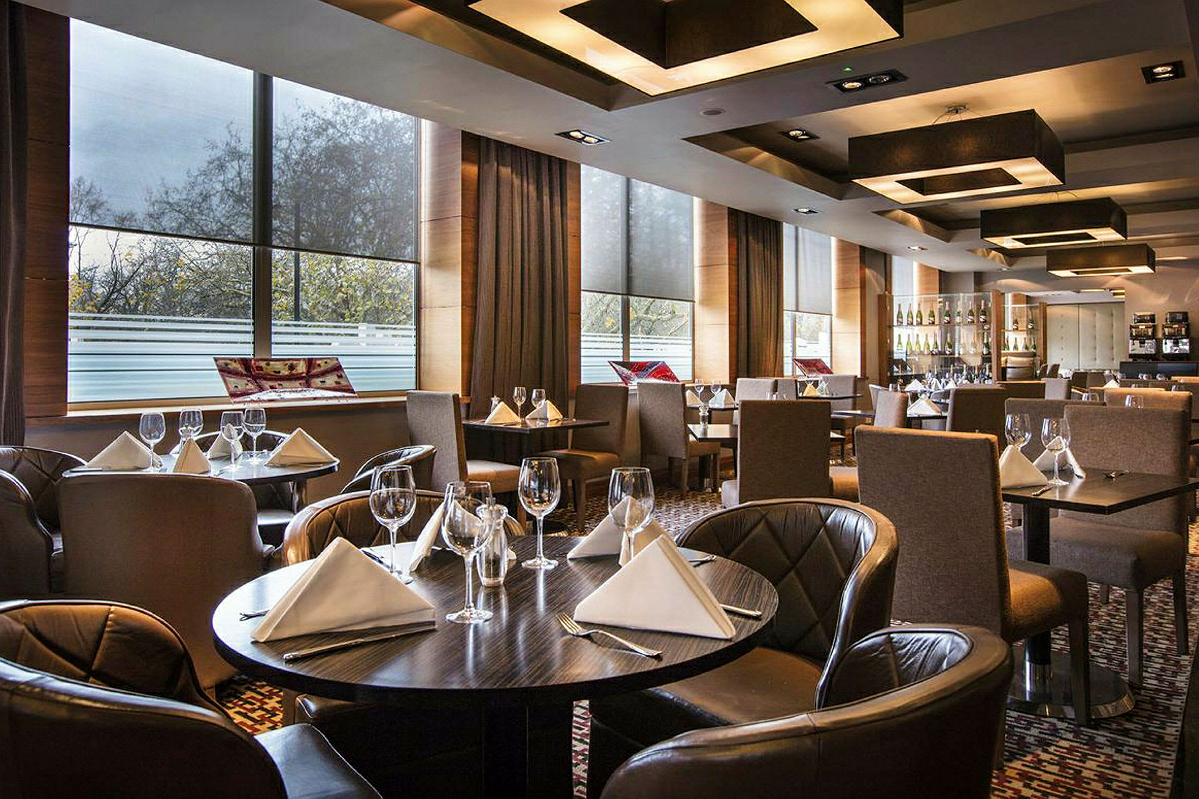 Ett elegant restaurang med dukade bord med vita servetter och vinglas. (AI-genererad text)