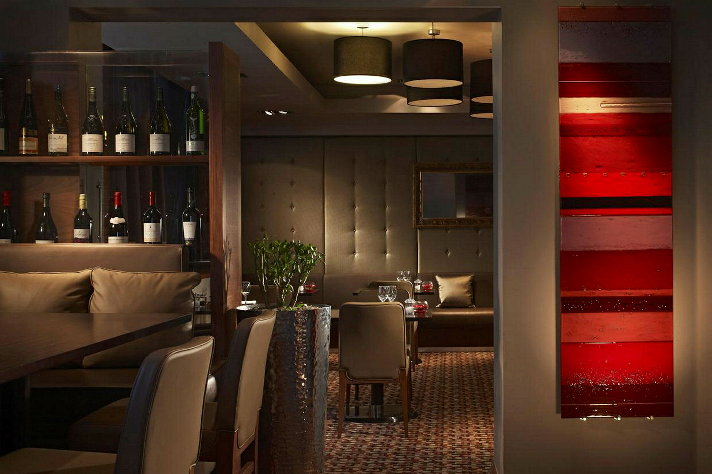Interiör av en restaurang med vinflaskor, sittplatser och dekorativa detaljer. (AI-genererad text)
