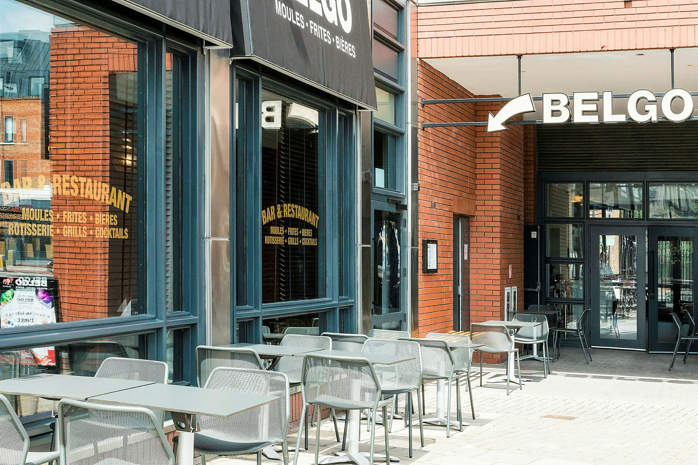Uteservering vid en restaurang med en skylt som lyder 'Belgo'. (AI-genererad text)