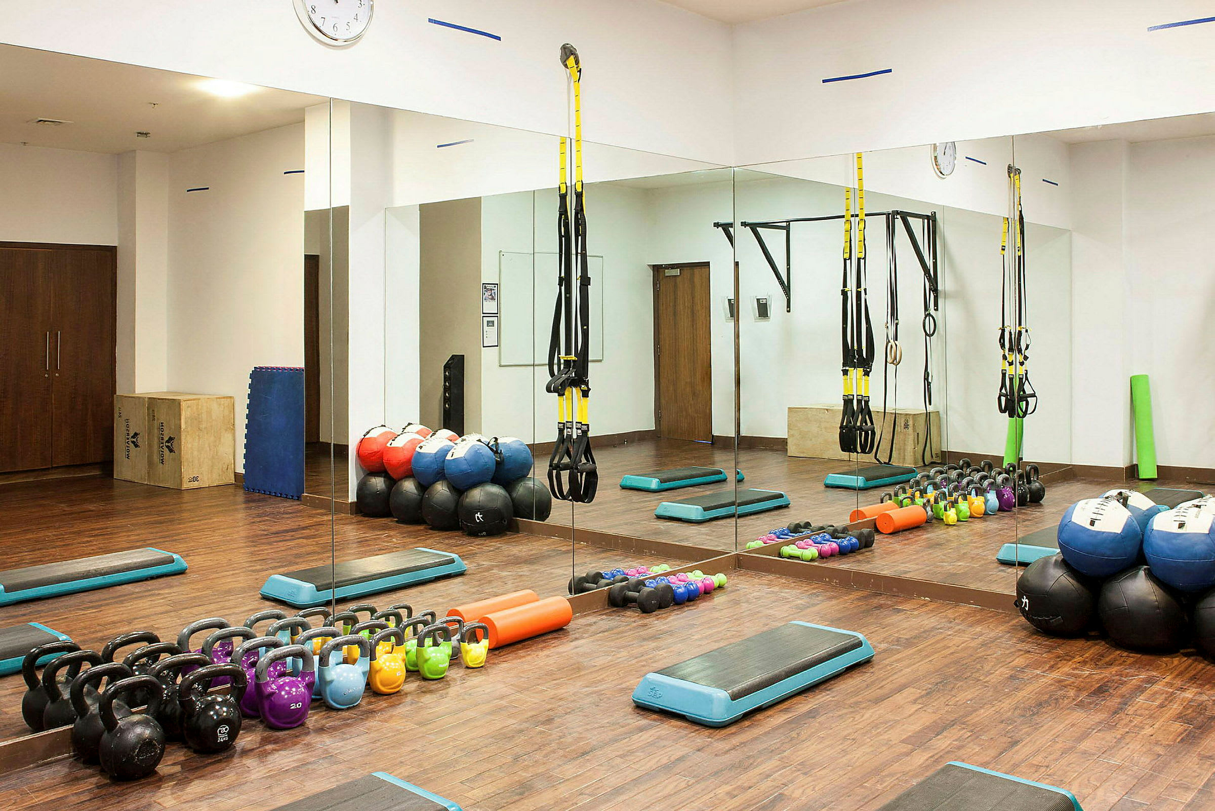 Ett gymrum med träningsutrustning som kettlebells, medicinbollar och remmar. (AI-genererad text)