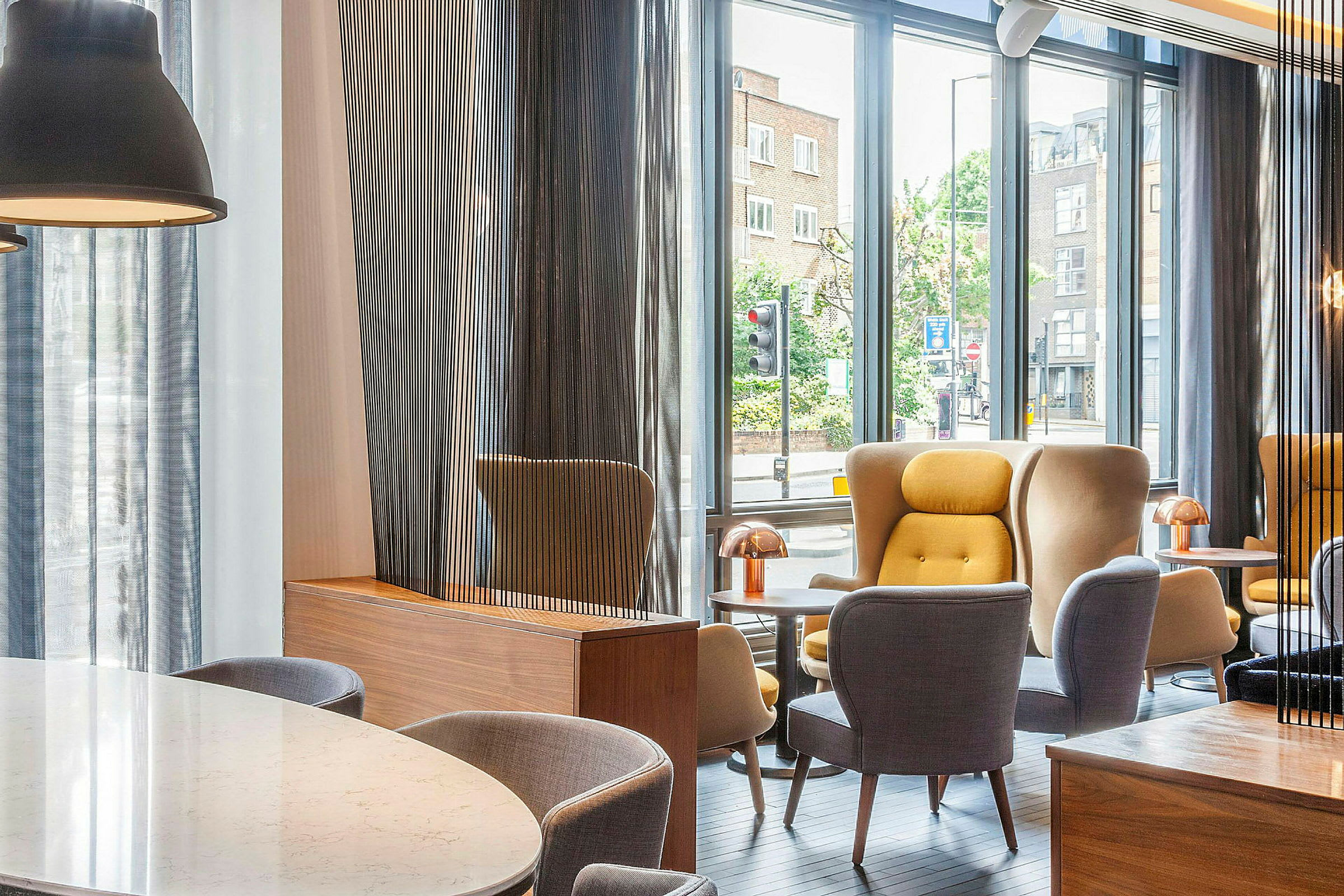 En modern lounge med stora fönster och bekväma sittmöbler. (AI-genererad text)