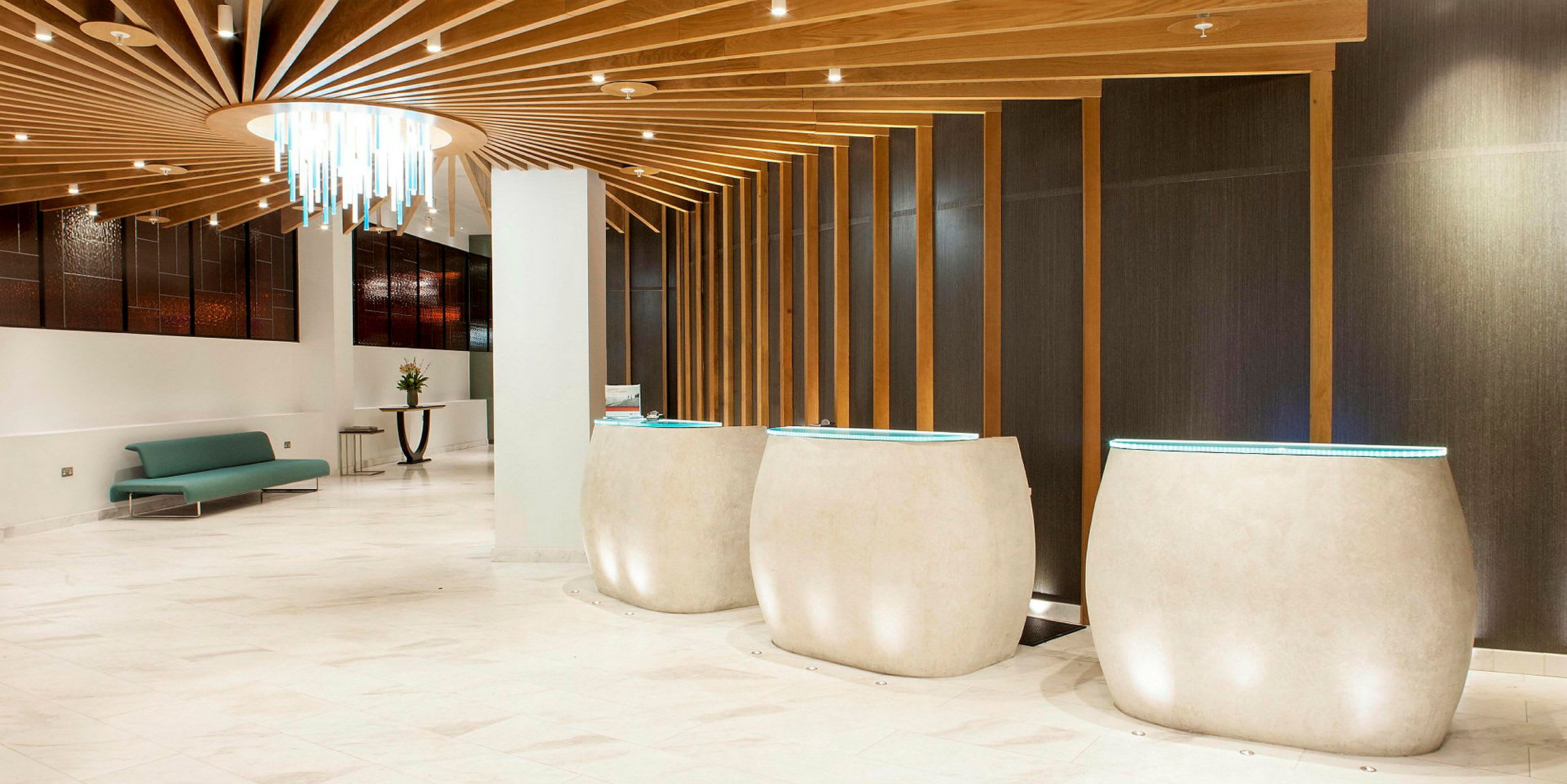 Modern lobby med ljusa golv, designmöbler och dekorativ ljuskrona. (AI-genererad text)