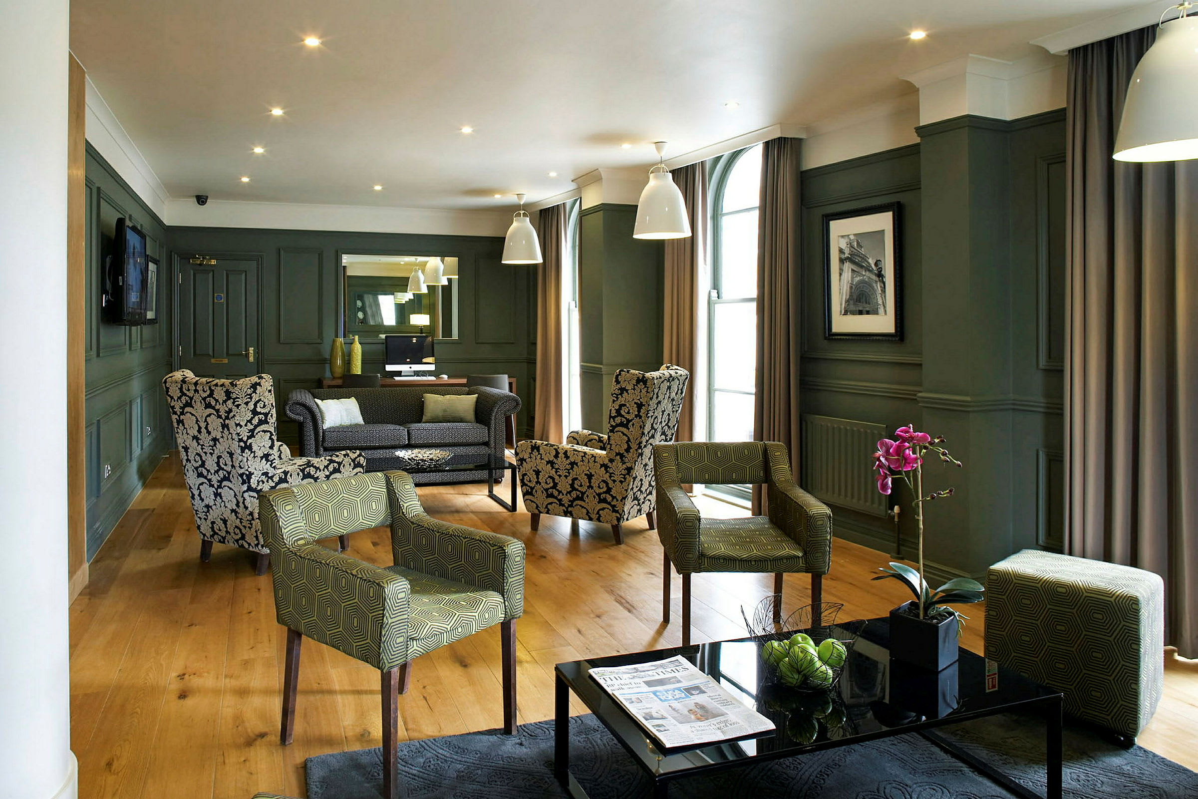 Ett elegant hotelloungeområde med fåtöljer och soffor, prydnadsväxter och modern inredning. (AI-genererad text)