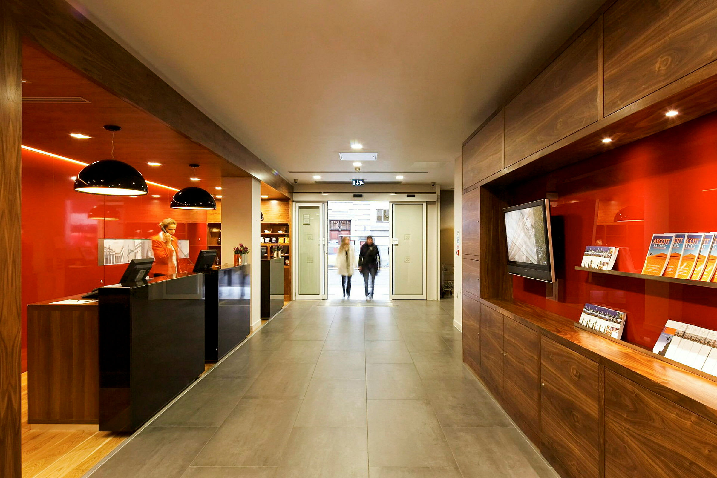 Reception med modern inredning och informationsbroschyrer, belägen nära en glasentré. (AI-genererad text)