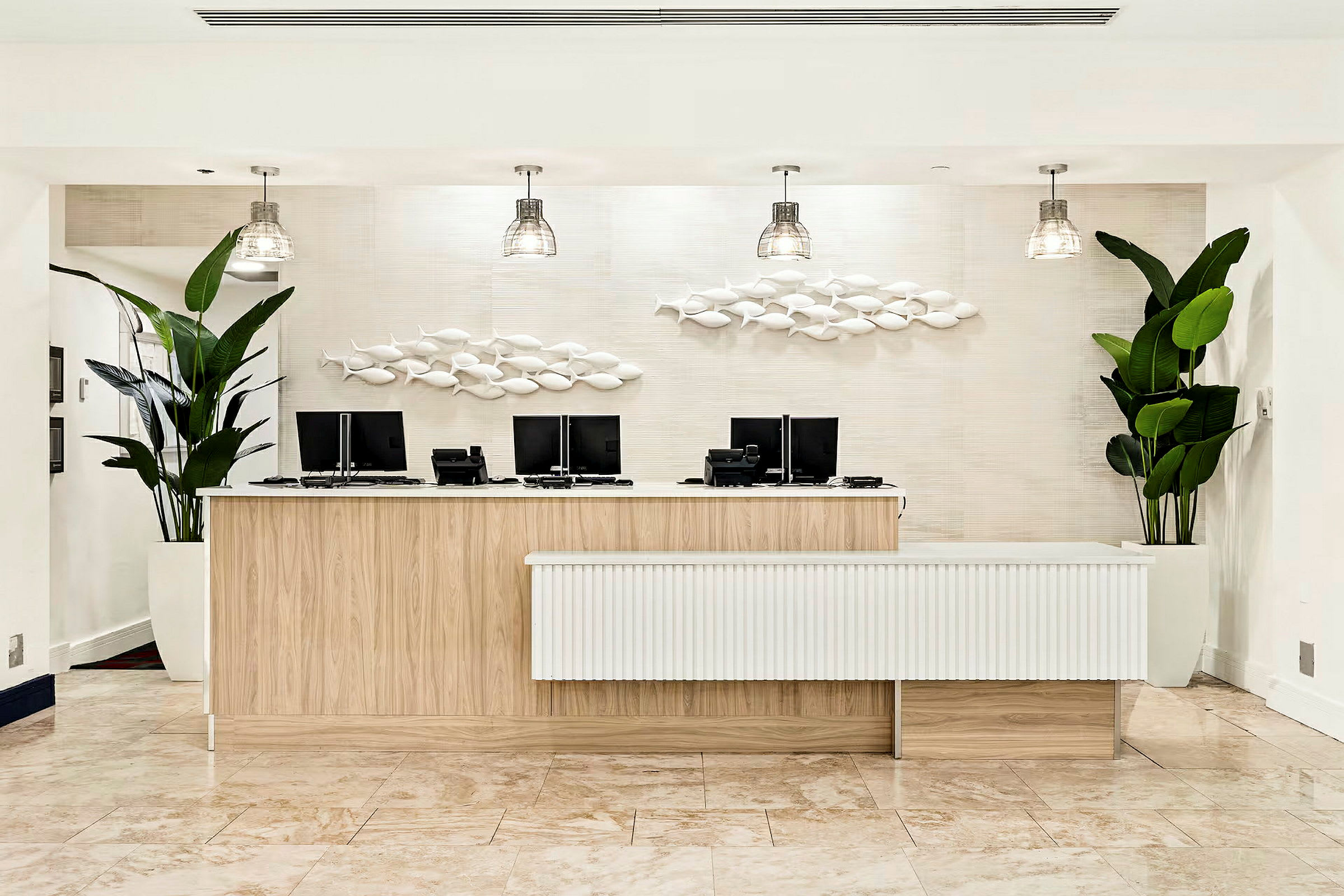 Reception med träinredning, datorskärmar och dekorativa väggprydnader samt gröna växter på båda sidor. (AI-genererad text)