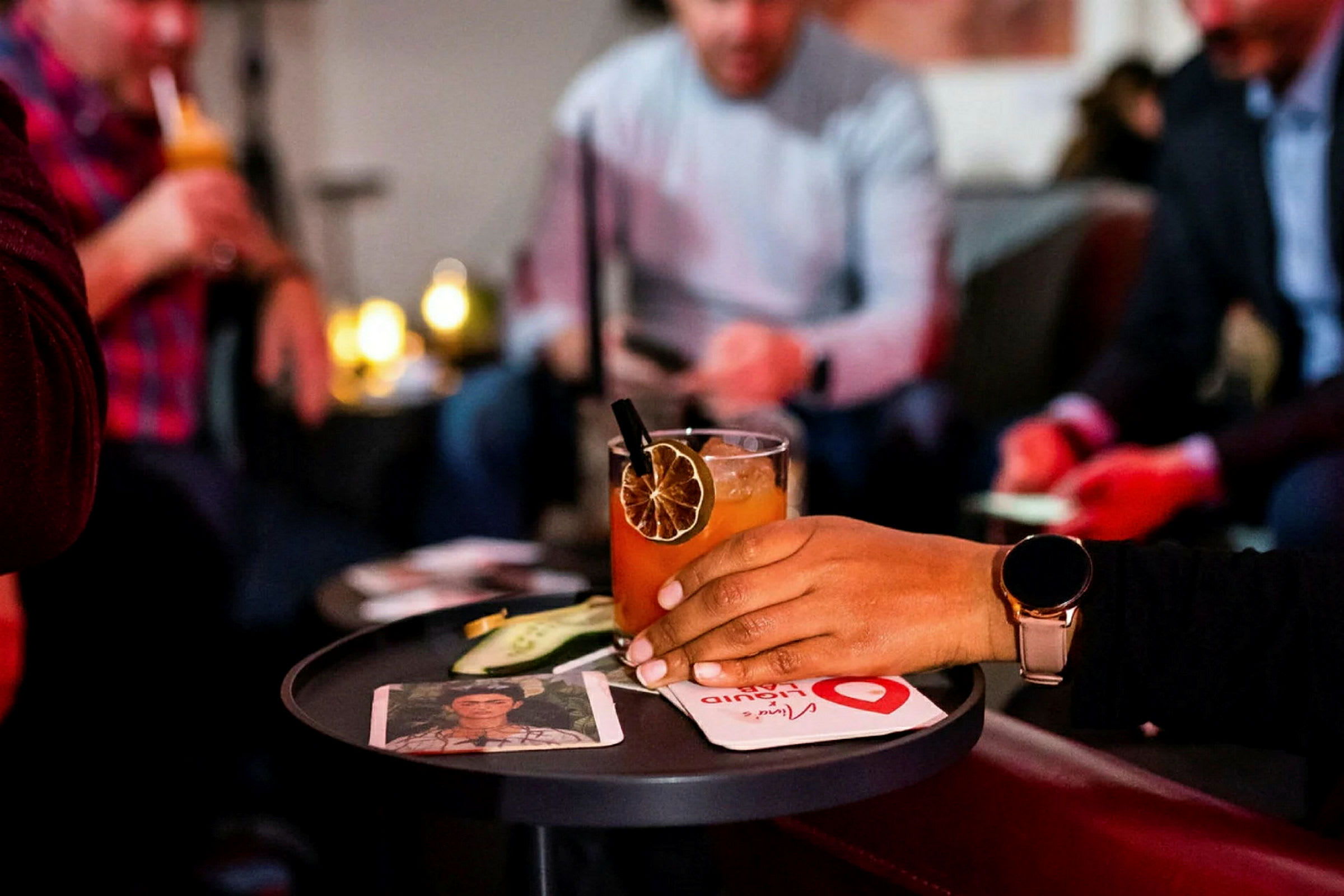 Människor samlade omkring ett bord med drinkar och drinktillbehör. (AI-genererad text)