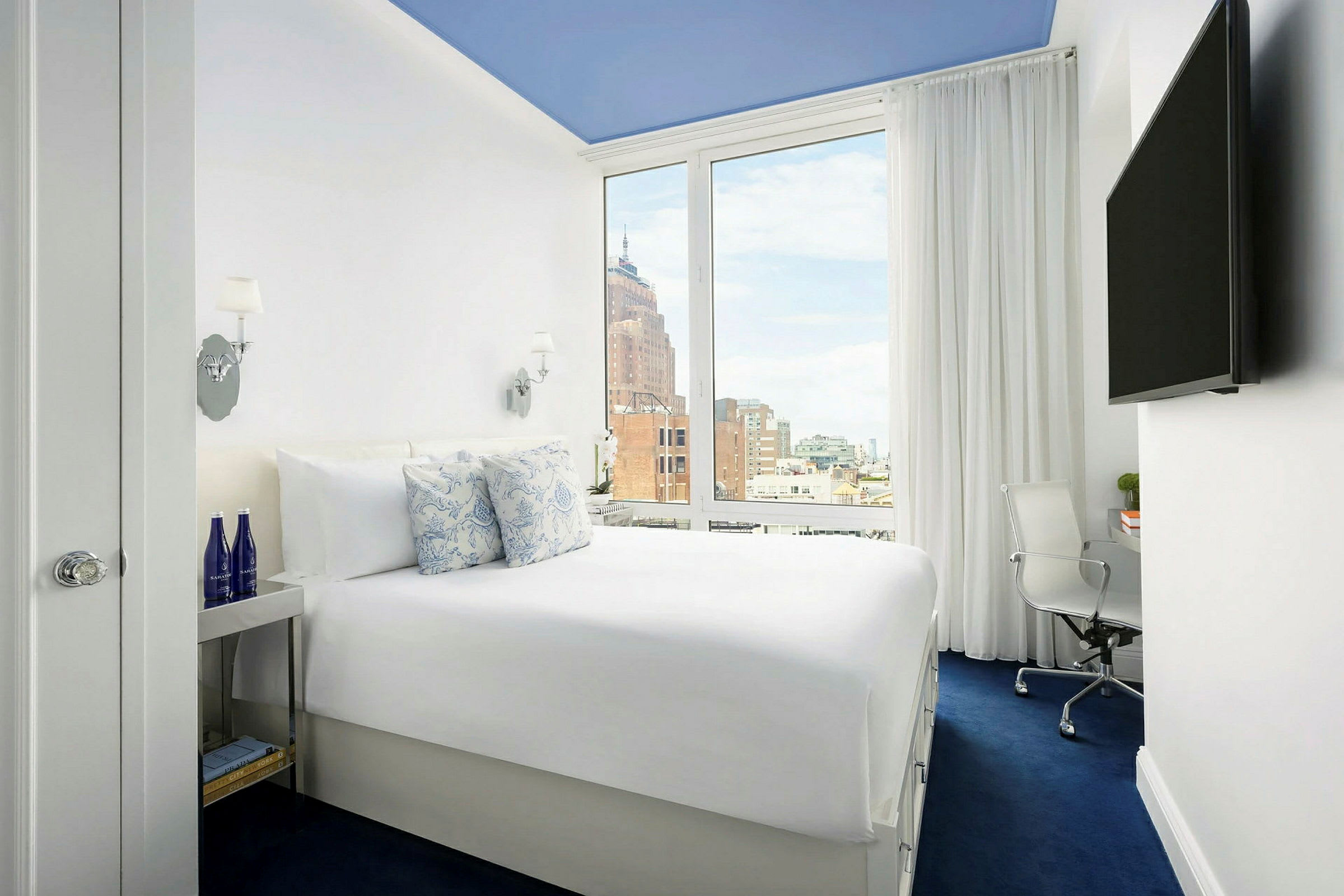 Bild av ett hotellrum med en bekväm dubbelsäng, ett stort fönster och modern inredning. (AI-genererad text)