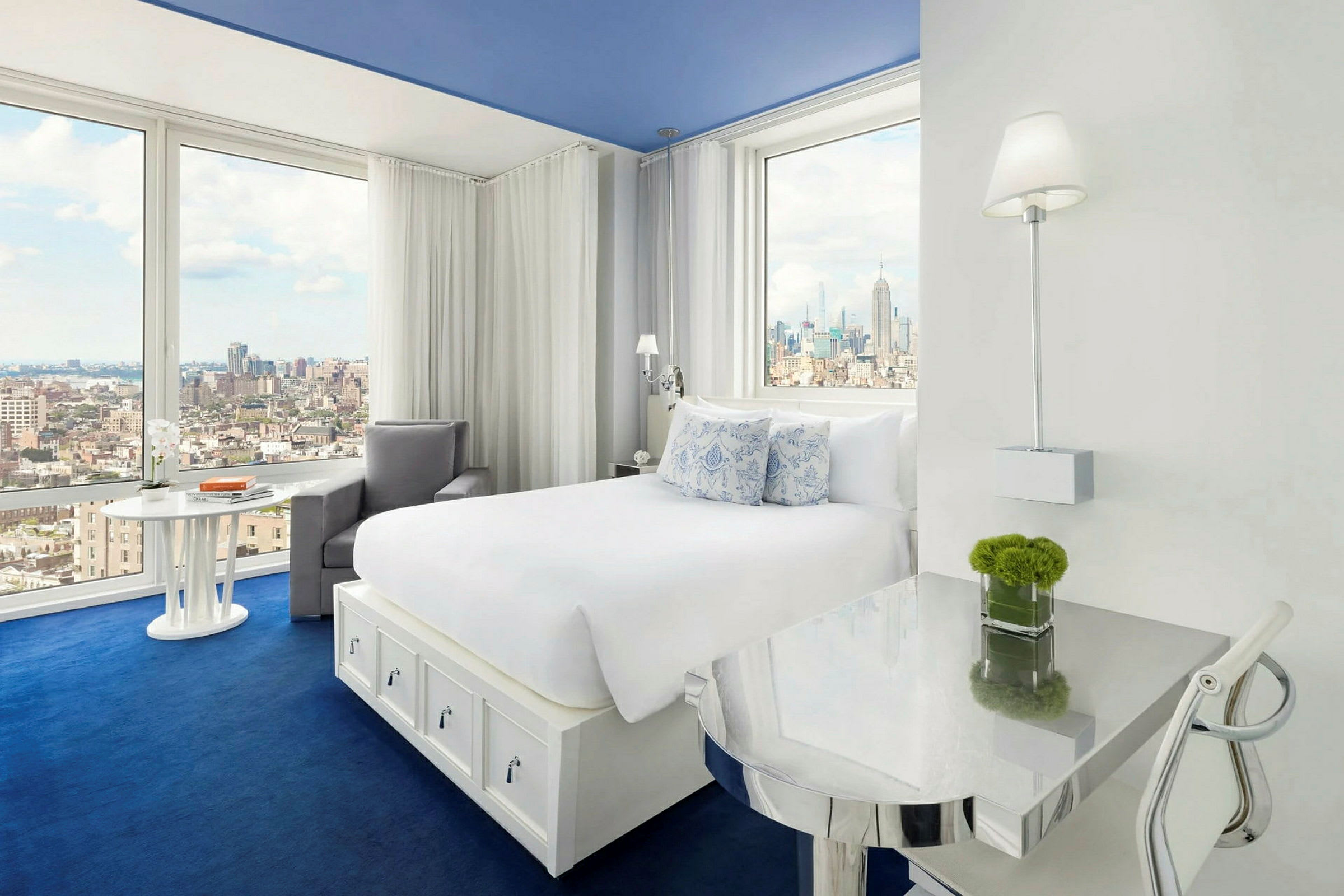 Ett ljust hotellrum med stor säng, fönster med stadsutsikt och modern inredning. (AI-genererad text)