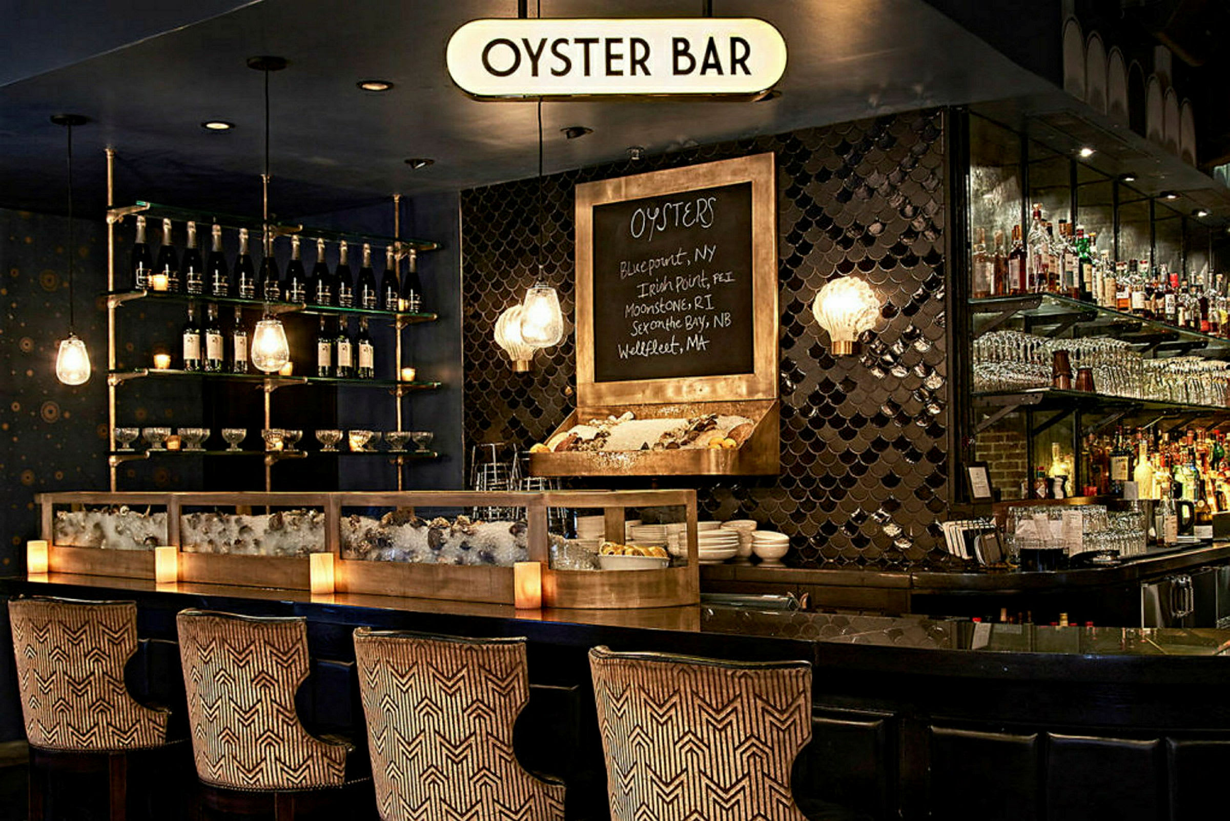 En stilfull oysterbar med en disk fylld med is och ostron, flaskor och glas på hyllor samt dekorativa lampor. (AI-genererad text)