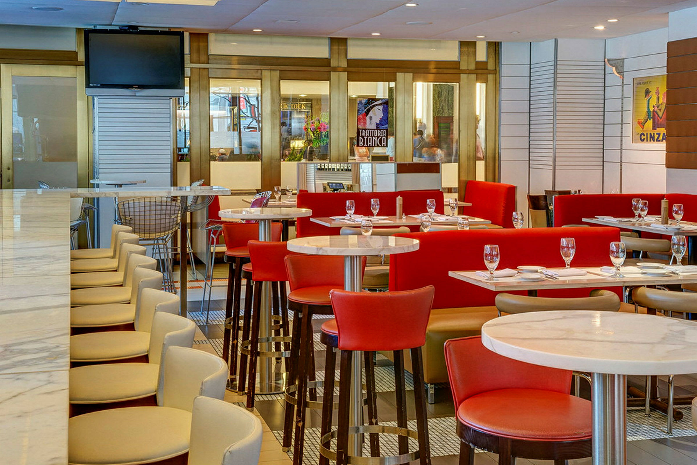 Ett modernt restauranginteriör med bord, stolar och en bar med höga stolar. (AI-genererad text)