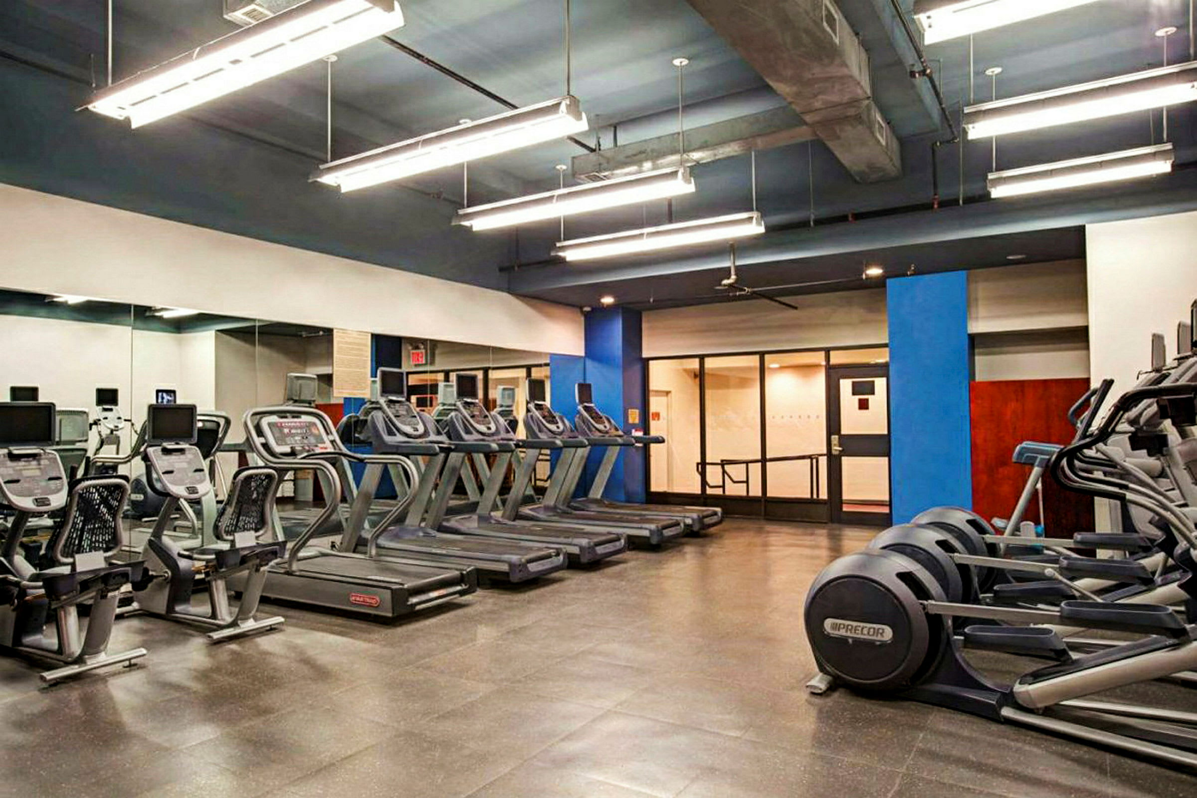 Ett gym med flera löpband, träningscyklar och andra träningsmaskiner. (AI-genererad text)