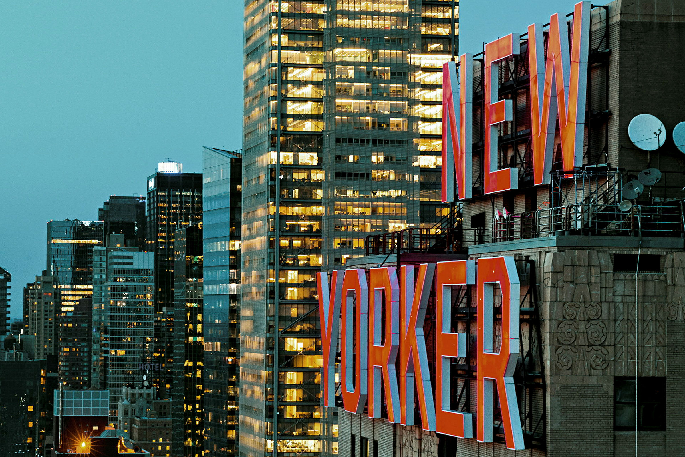 Bild på en stadsbyggnad med texten "New Yorker" i stora röda bokstäver, och flera moderna byggnader i bakgrunden. (AI-genererad text)