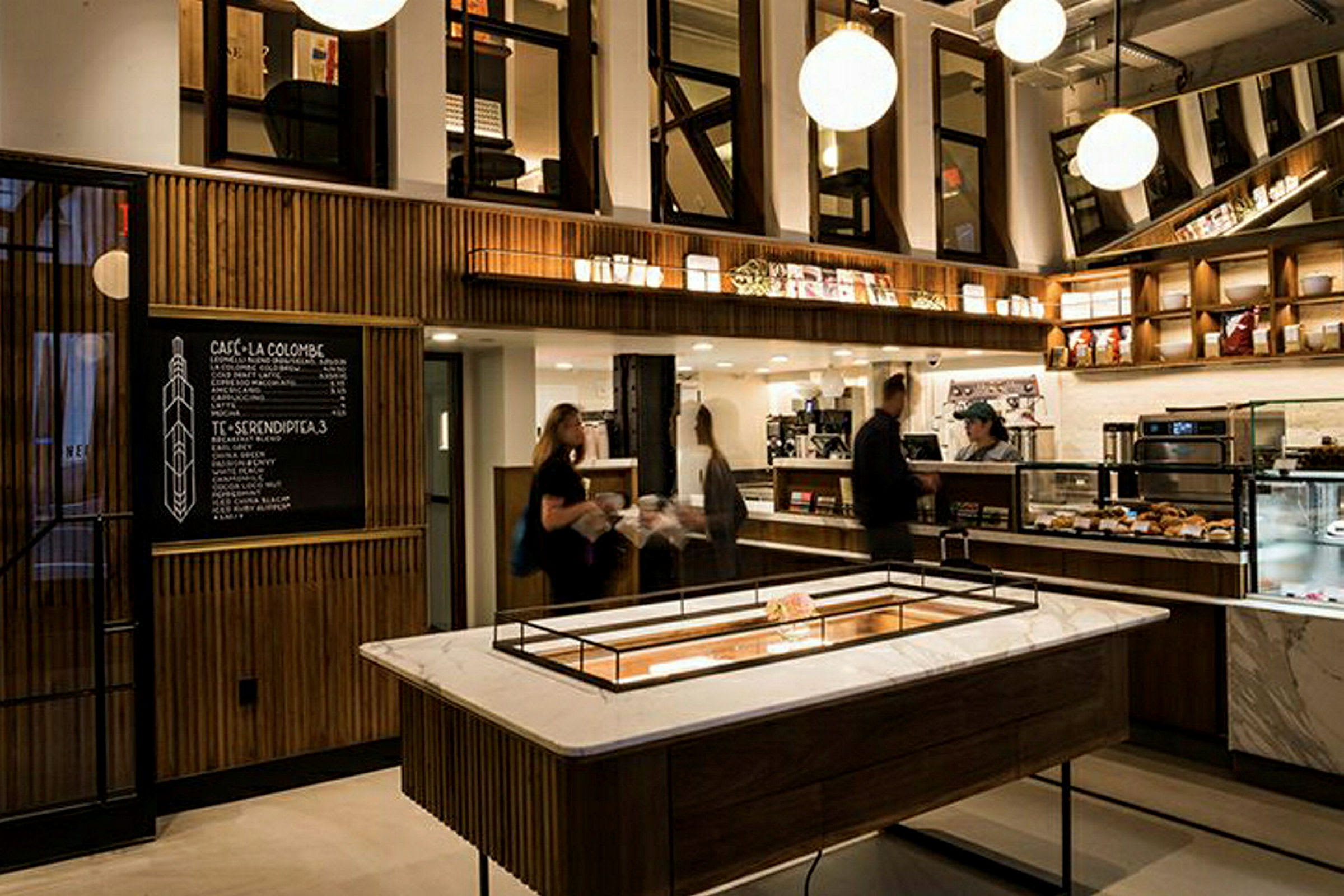 Bild av en modern kaffebar med elegant inredning, väggmonterade hyllor och en meny på en svart tavla. (AI-genererad text)
