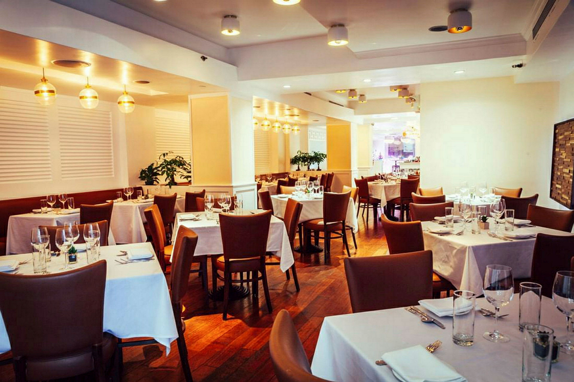 En elegant restaurang med dukade bord och bruna stolar. (AI-genererad text)