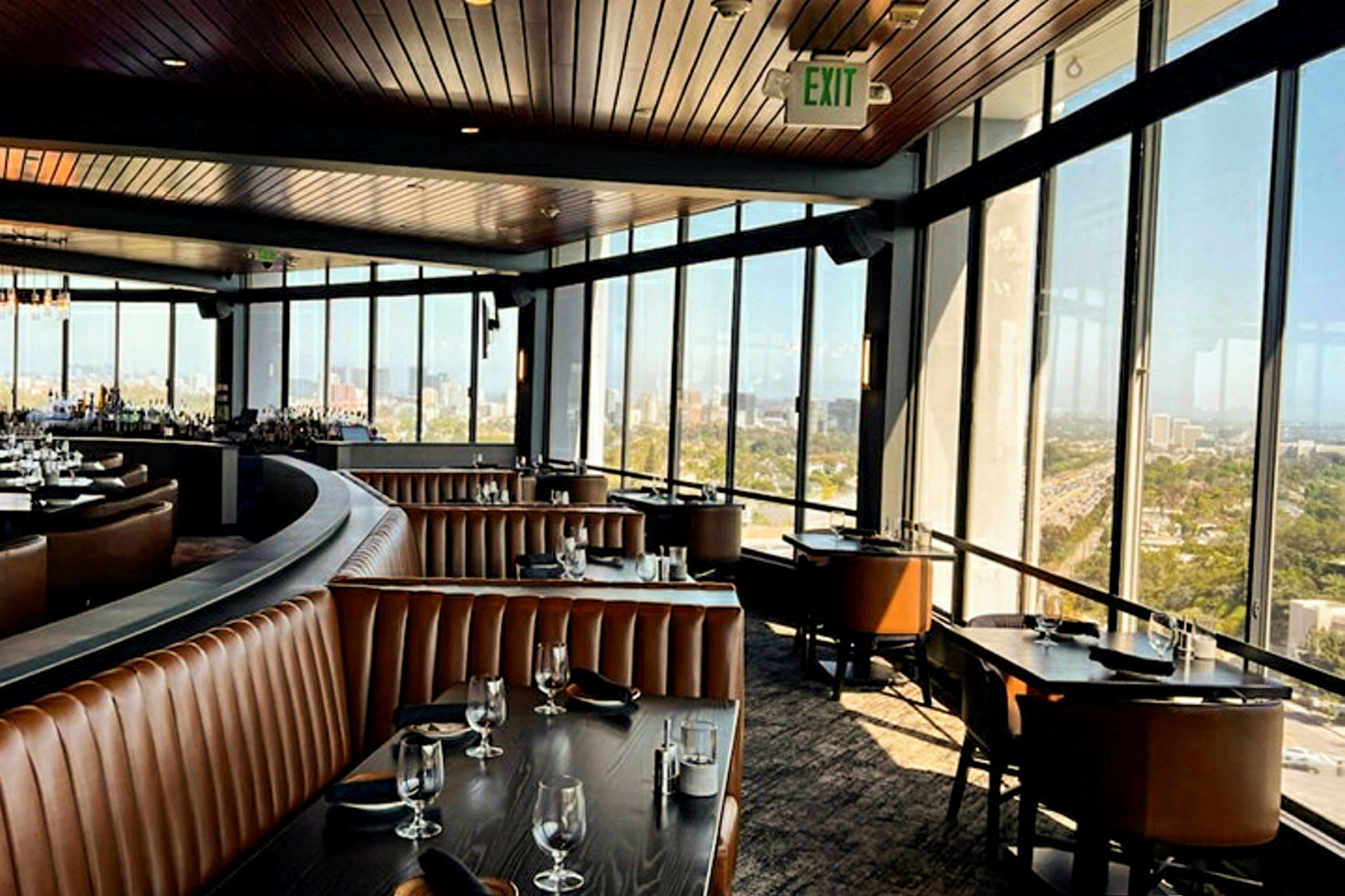 Interiör av en rymlig restaurang med panoramavy genom stora fönster. (AI-genererad text)