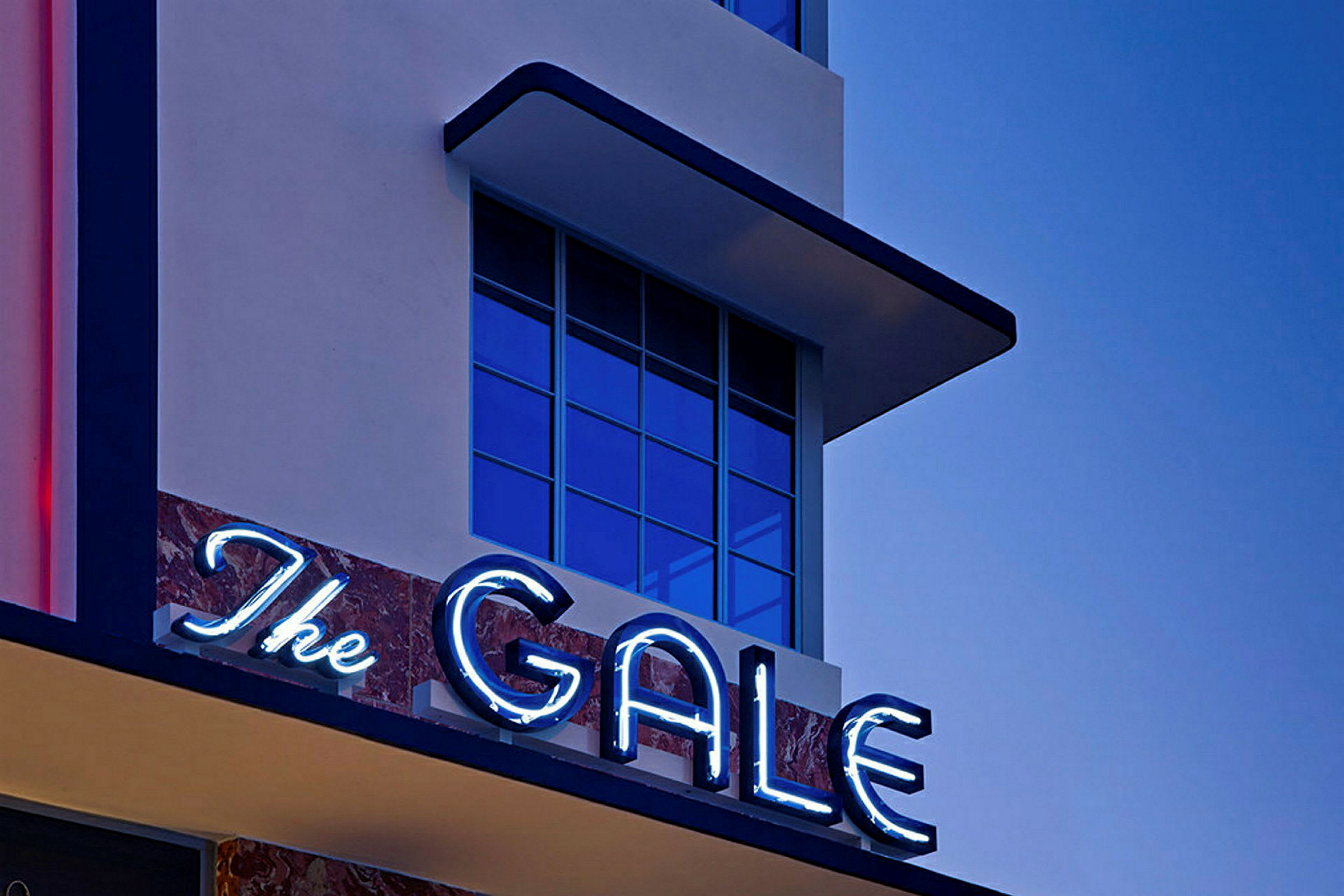 Byggnadsfasad med ett neonskylt med texten 'The Gale'. (AI-genererad text)
