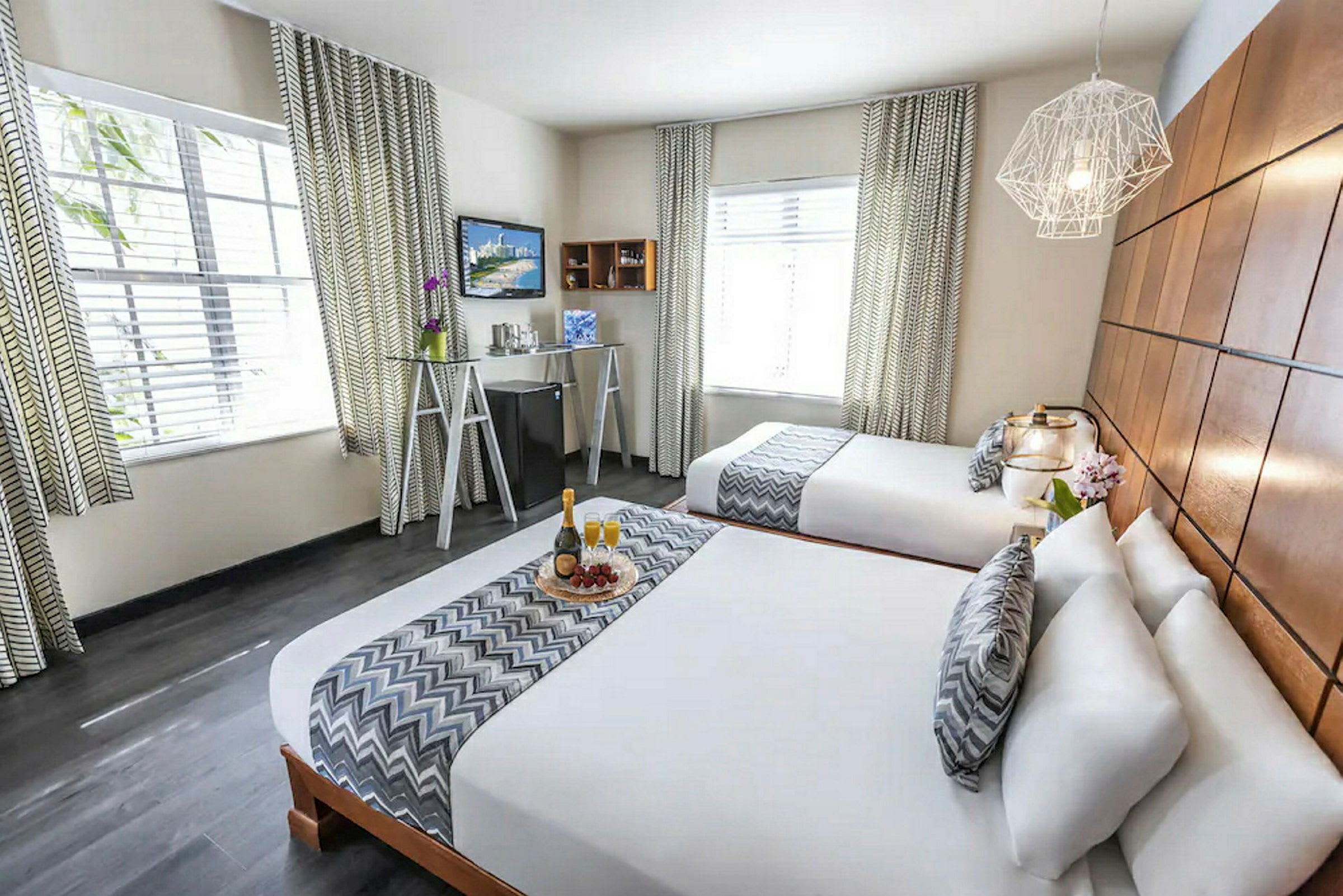 Ett hotellrum med två dubbelsängar, elegant inredning och dekorativa detaljer. (AI-genererad text)