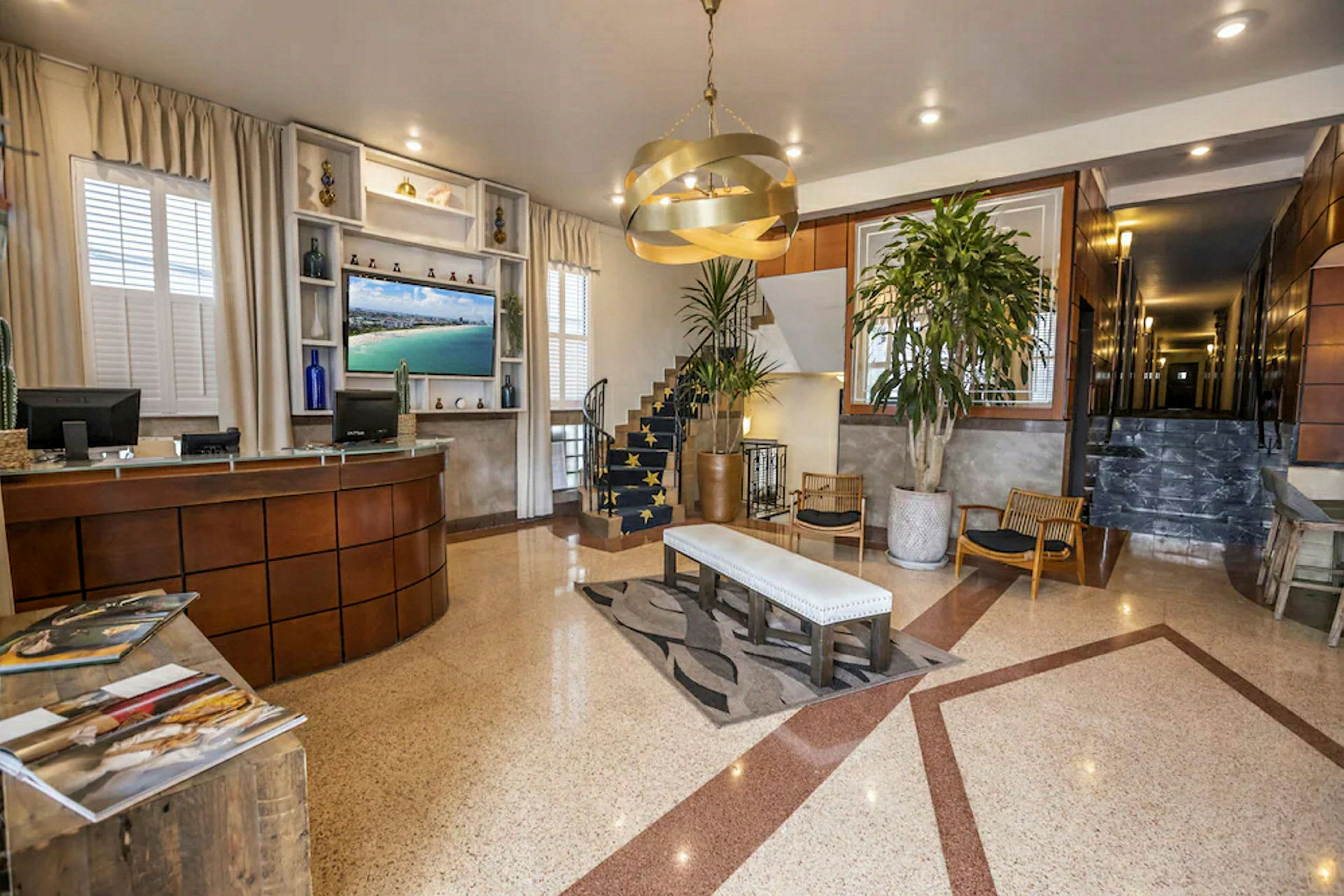 Hotelllobby med receptionsdisk, sittområde och en trappa. (AI-genererad text)