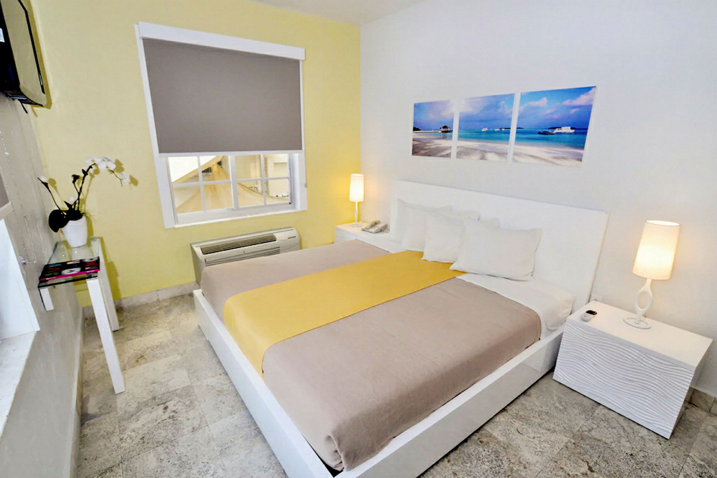 Ett hotellrum med en dubbelsäng, vit inredning och dekorationer. (AI-genererad text)