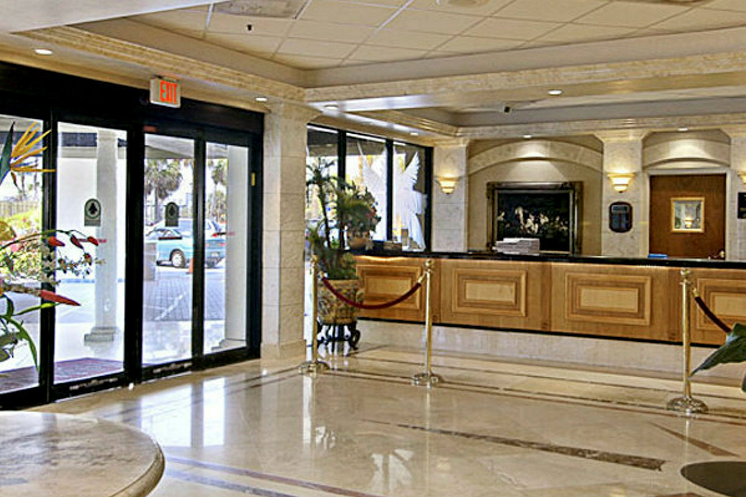 Hotellets lobby med reception och automatöppnade glasdörrar. (AI-genererad text)