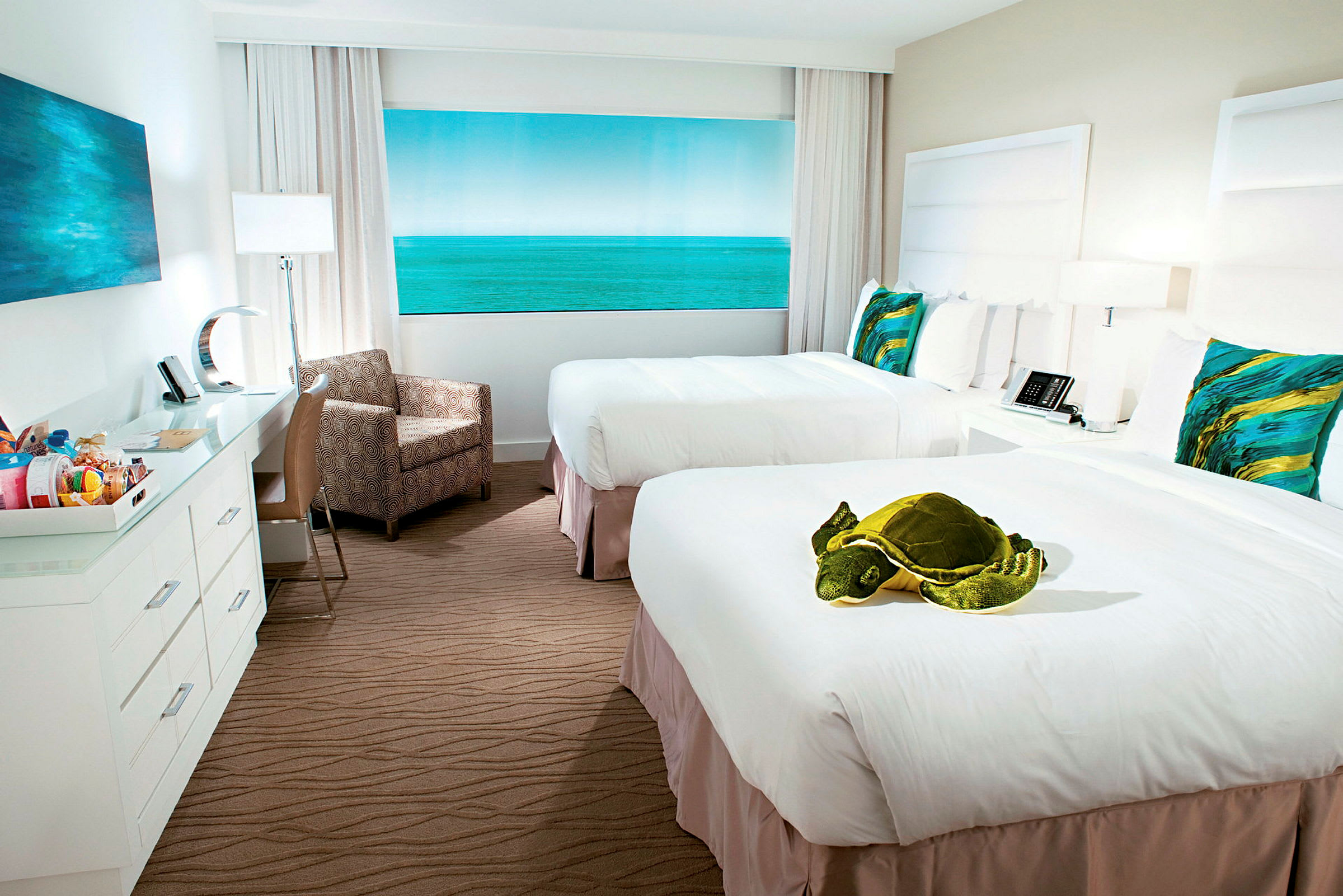 Hotellrum med två sängar, en stor leksakssköldpadda placeras på den ena sängen. (AI-genererad text)