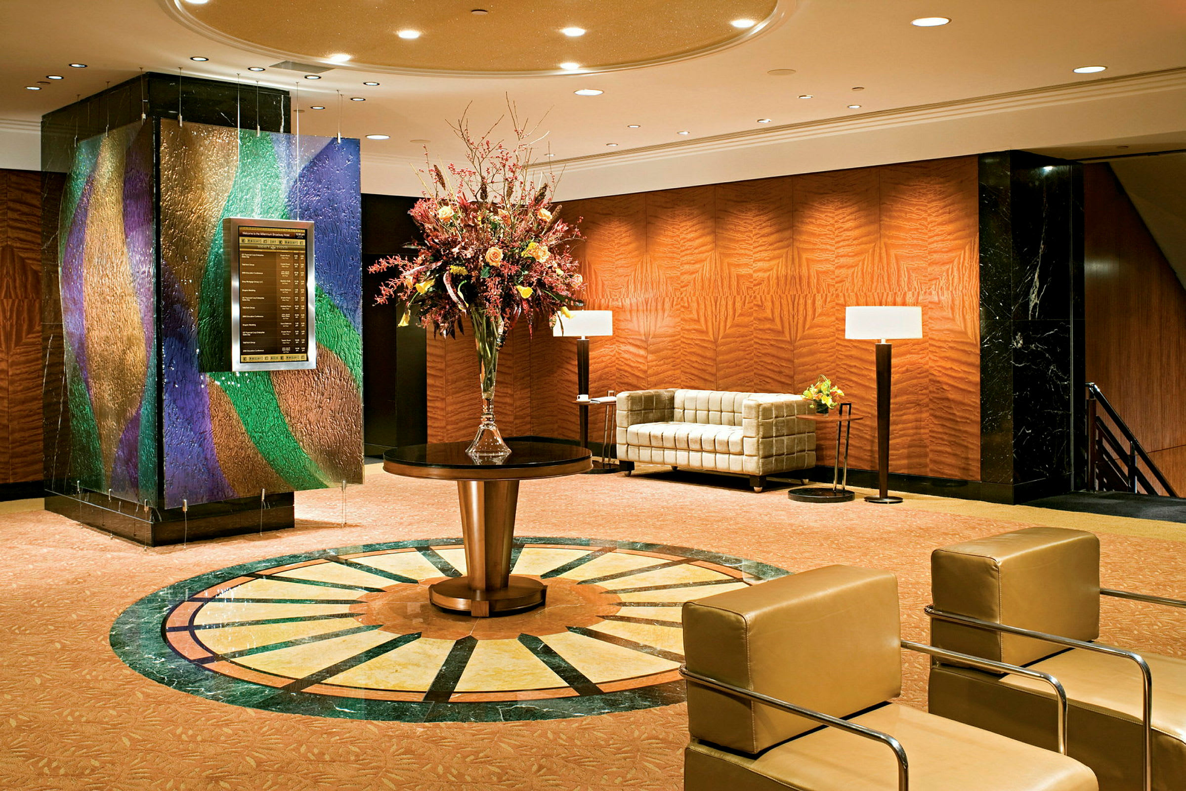 Hotellobby med soffor, bord och en stor blomdekoration. (AI-genererad text)