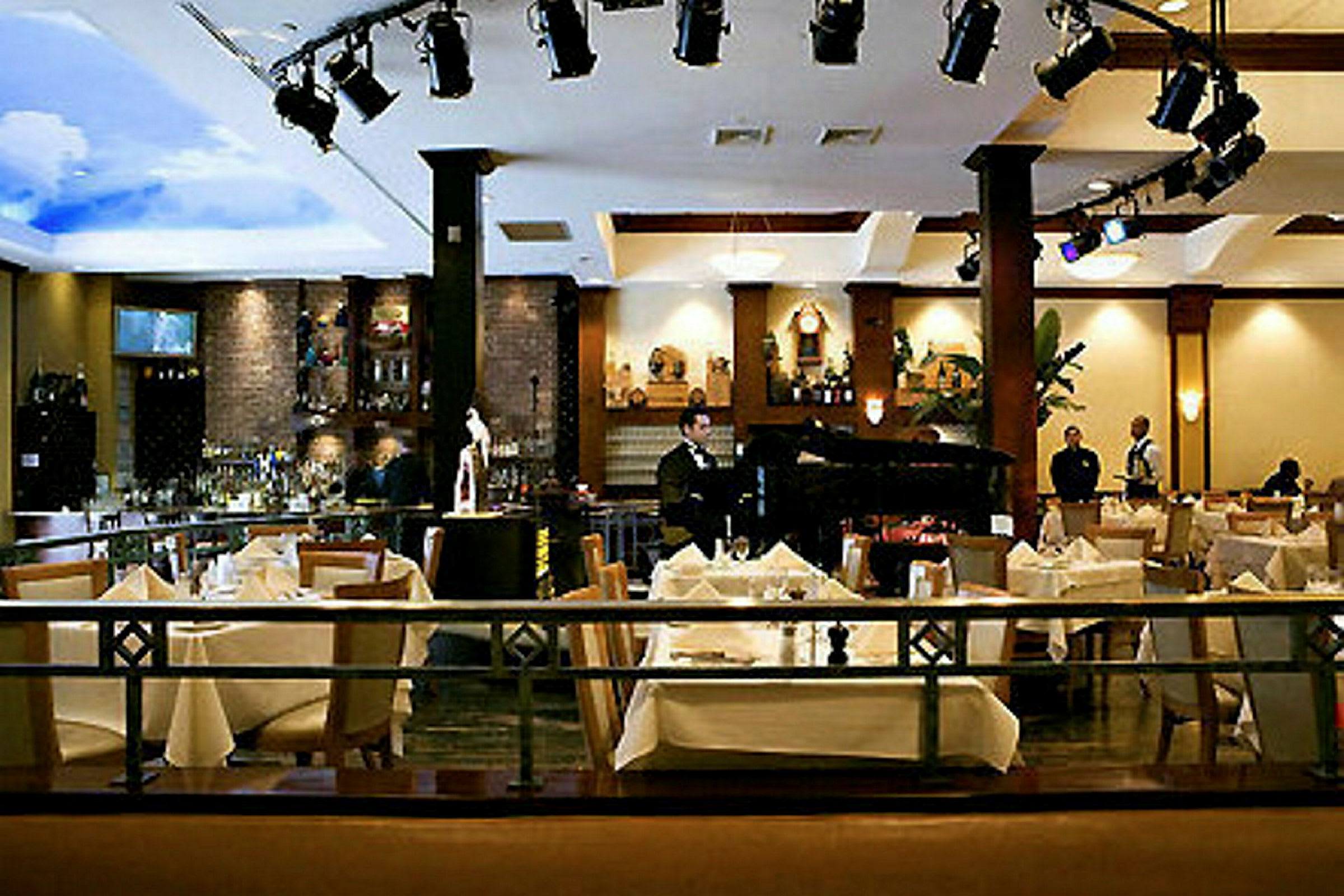 En elegant restaurang med sittplatser, dukade bord och en bar i bakgrunden. (AI-genererad text)