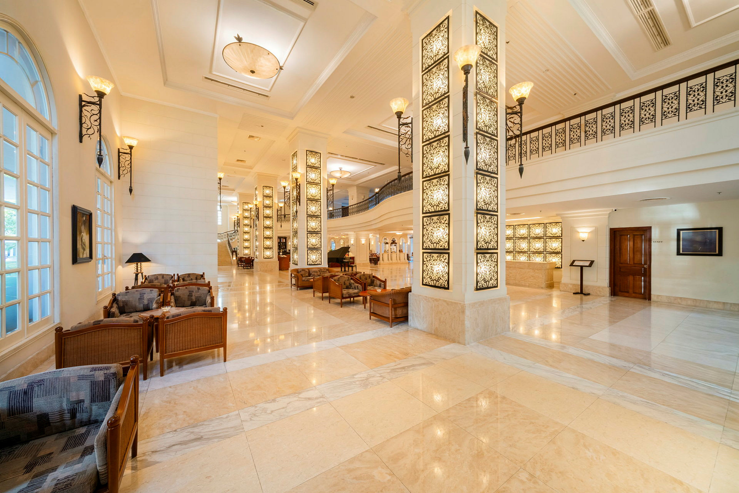 Elegant hotellfoajé med marmorgolv, dekorativa pelare och sittgrupper. (AI-genererad text)