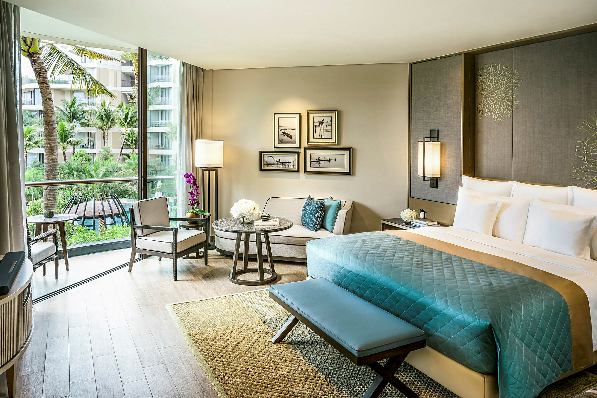 Ett elegant hotellrum med en stor säng, en sittgrupp och ett stort fönster med utsikt över palmträd och en pool. (AI-genererad text)