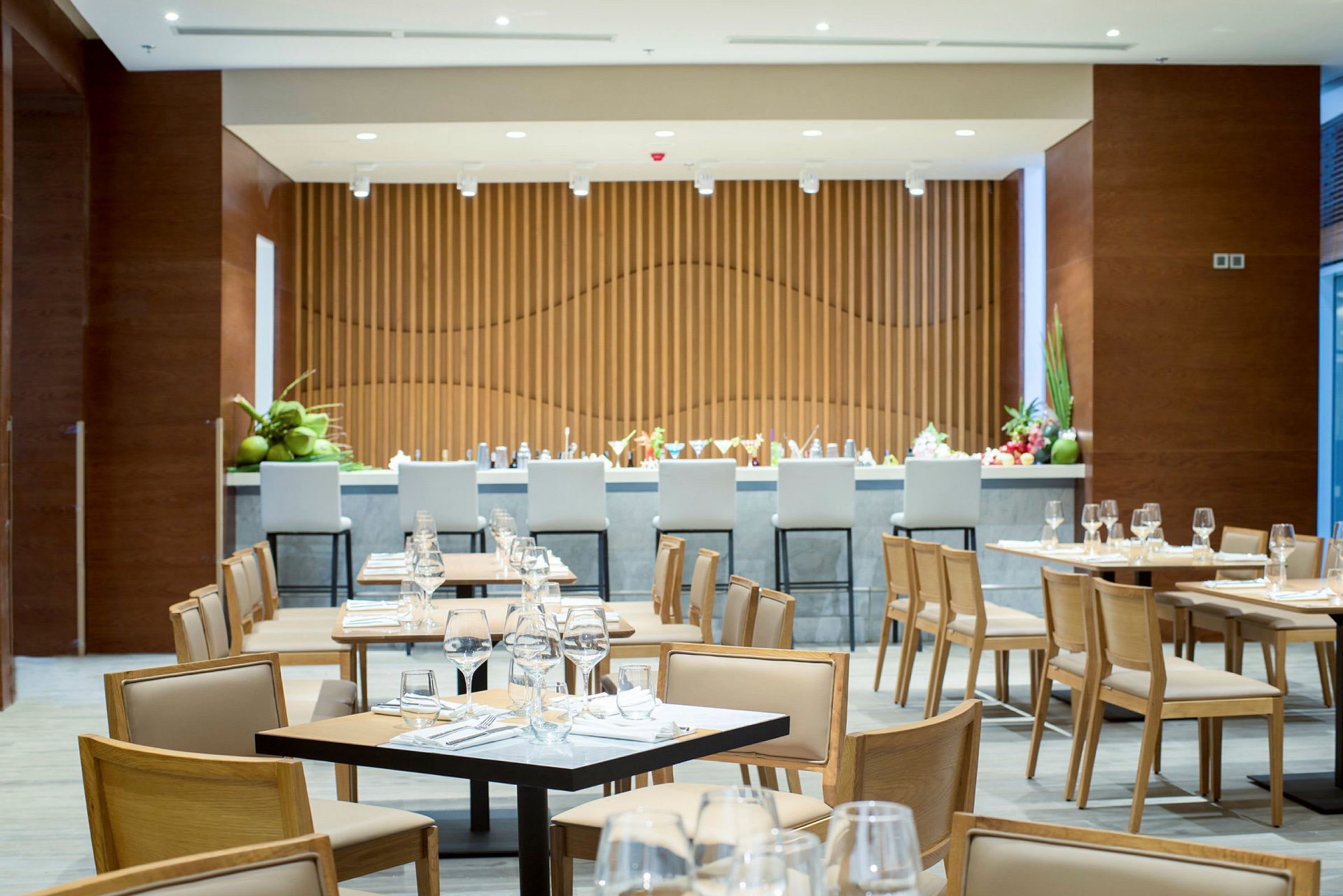 En restaurang med dukade bord och stolar samt en bardisk i bakgrunden. (AI-genererad text)