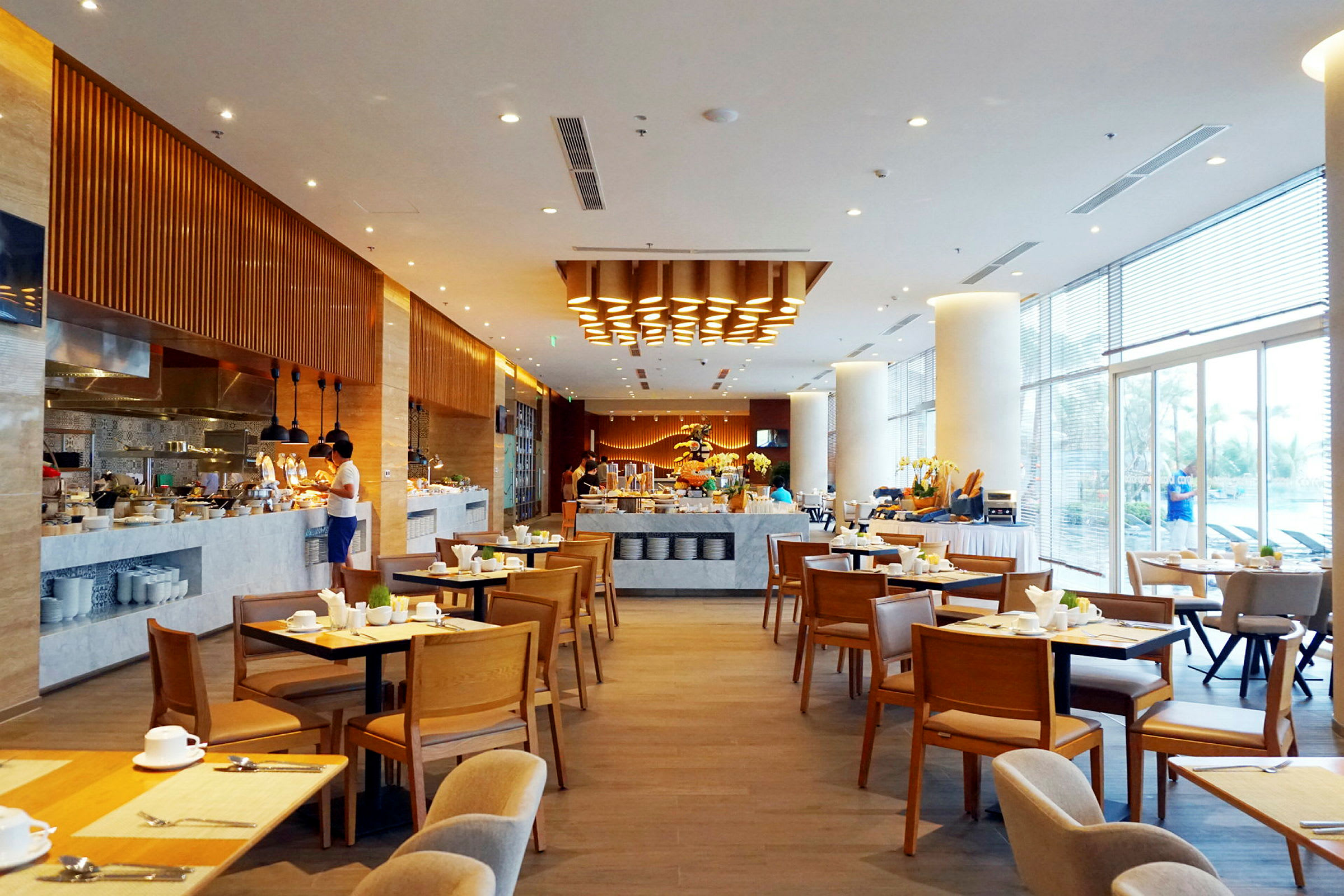 En rymlig restaurang med bord och stolar, en bufféstation och modern belysning. (AI-genererad text)