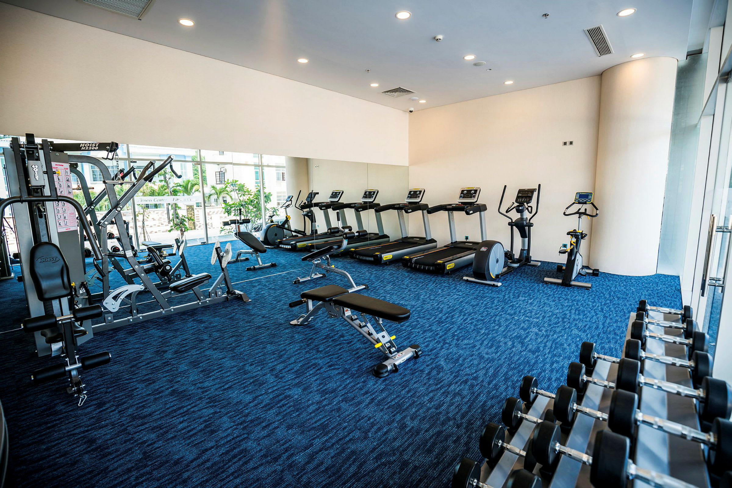 Ett gym utrustat med löpband, träningscyklar, träningsmaskiner och fria vikter. (AI-genererad text)